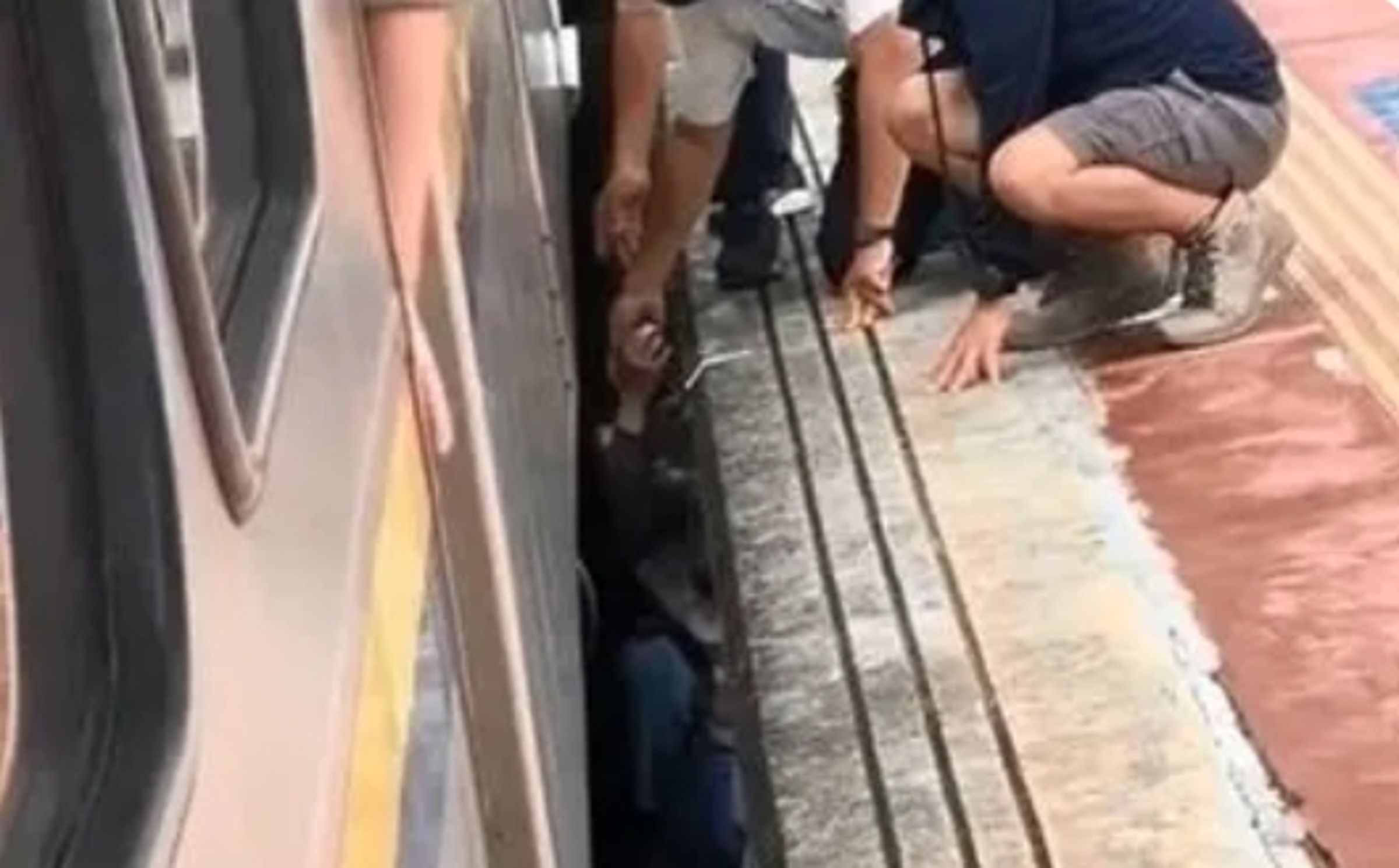 一名女乘客跌入月台與車之間的縫隙,眾人合力將她救出。(翻攝畫面)