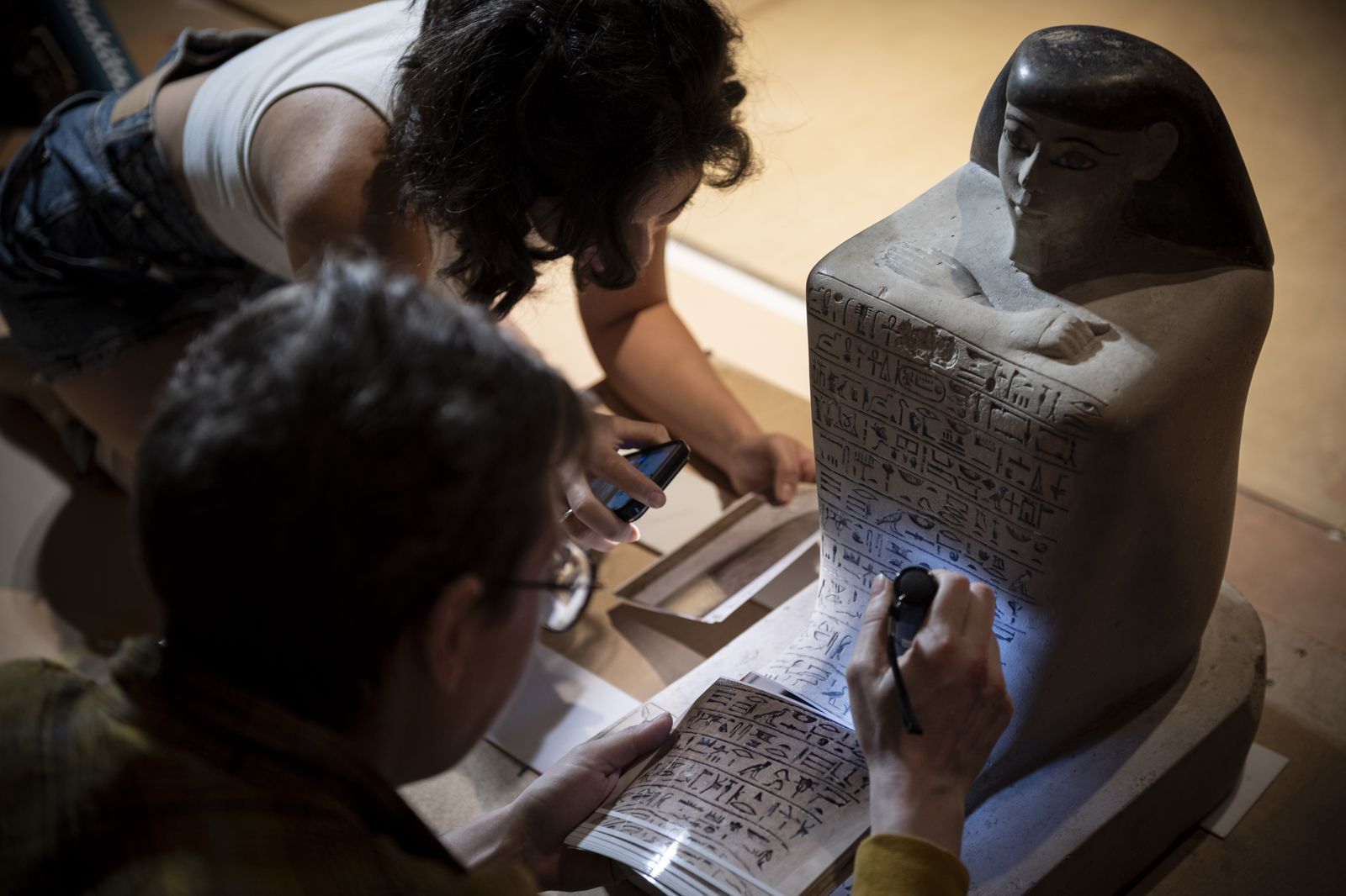 工作人員仔細確認官員塞內弗「方塊雕像」上的銘文。（奇美博物館提供）
