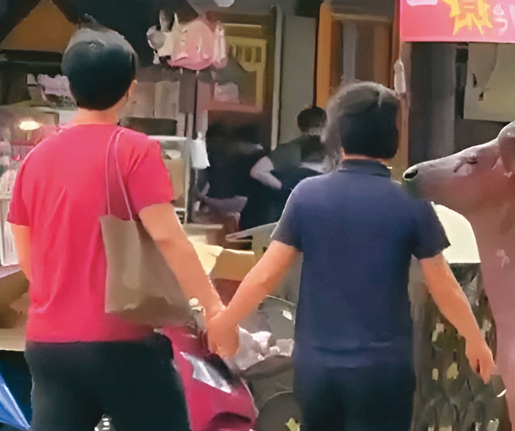 已婚政風主任L男(左)與法官助理K女(右)被直擊當街牽手。(讀者提供)