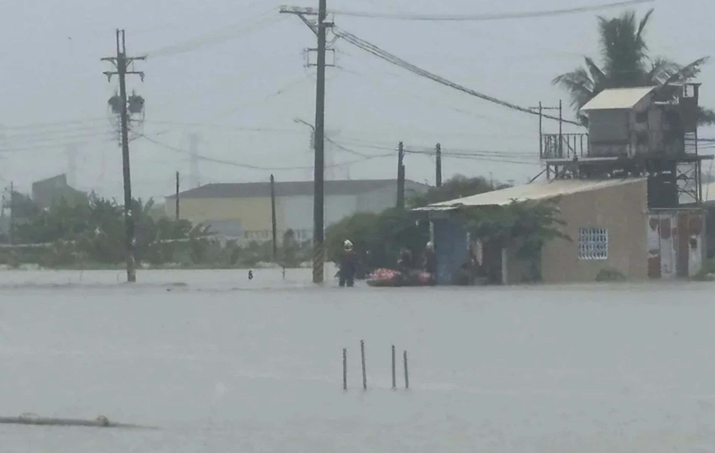高雄路竹因瞬間暴雨造成路面積水，有少年在工廠內顧機器睡著，意外遭大水包圍受困，警消出動橡皮艇成功救援。（翻攝畫面）