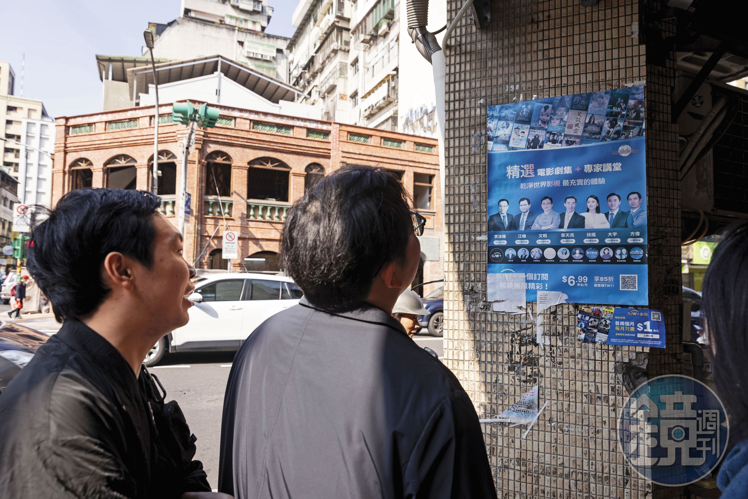 李穎(右)、多倫多方臉(左)訪台期間在街頭走動,無意看見牆面張貼斑駁的中國海外反共人士活動海報,2人駐足觀看許久。