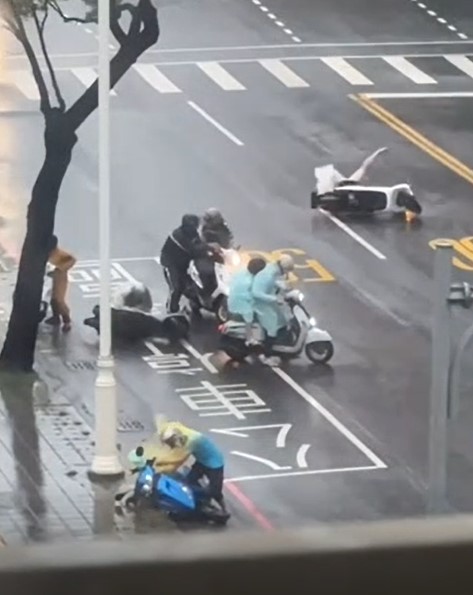 高雄港前鎮區路上,幾名騎士不敵強風倒地,模樣十分狼狽。(翻攝自記者爆料網)