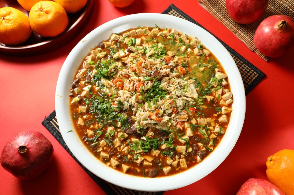 「蟹黃菲力麻婆豆腐」是朧粵餐廳的名廚簡捷明的創意料理，裴社長在原本食譜的基礎上調整食材，以菲力牛肉取代和牛，並用當季沙母的蟹黃和蟹肉增添鮮味。（何宗昇、鄭祺耀攝）