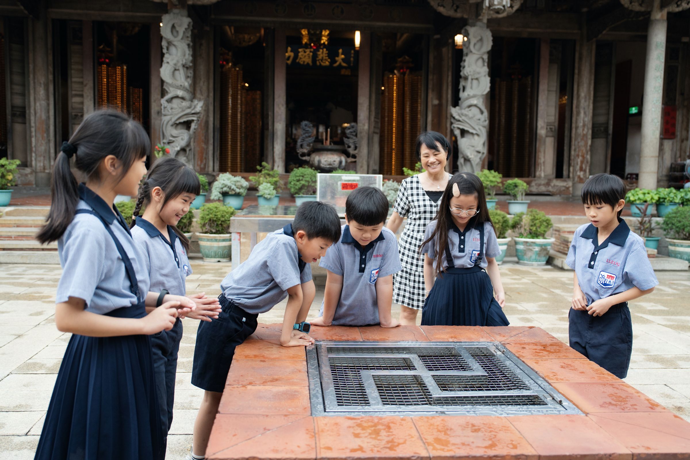 任教於鹿港國小的施淑津,帶領學生走訪龍山寺,認識家鄉文化。(攝影/陳巧羚)