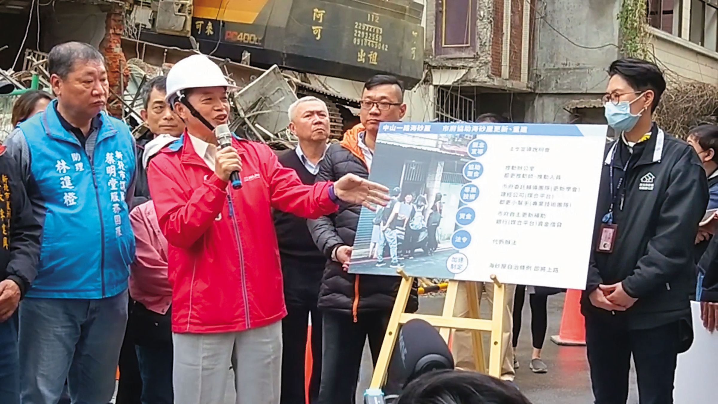 苦等建商協商未果，劉有祺（紅衣者）決定自己蓋房子，召集左鄰右舍，展開家園保衛戰。（翻攝新北市城鄉局YouTube）