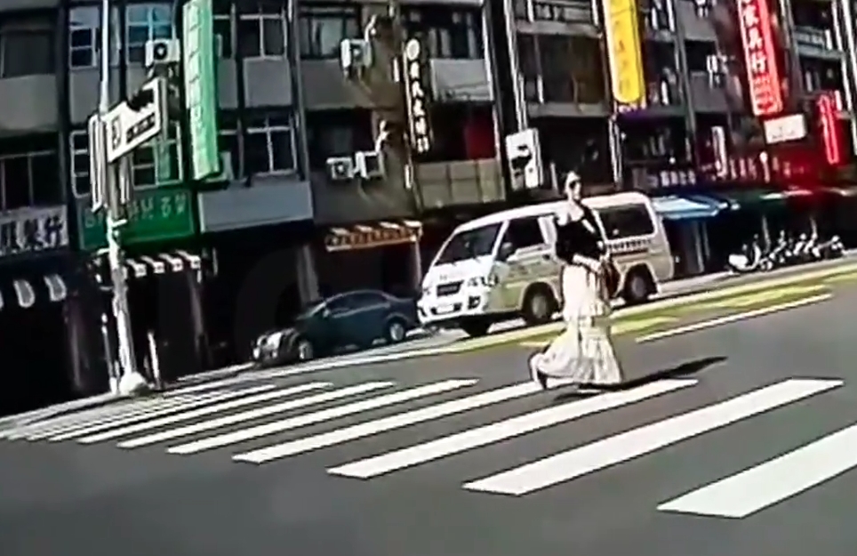 女子把自己當「麻豆明星」在斑馬線上擺pose，讓用路人看傻眼。（翻攝自社會事新聞影音）