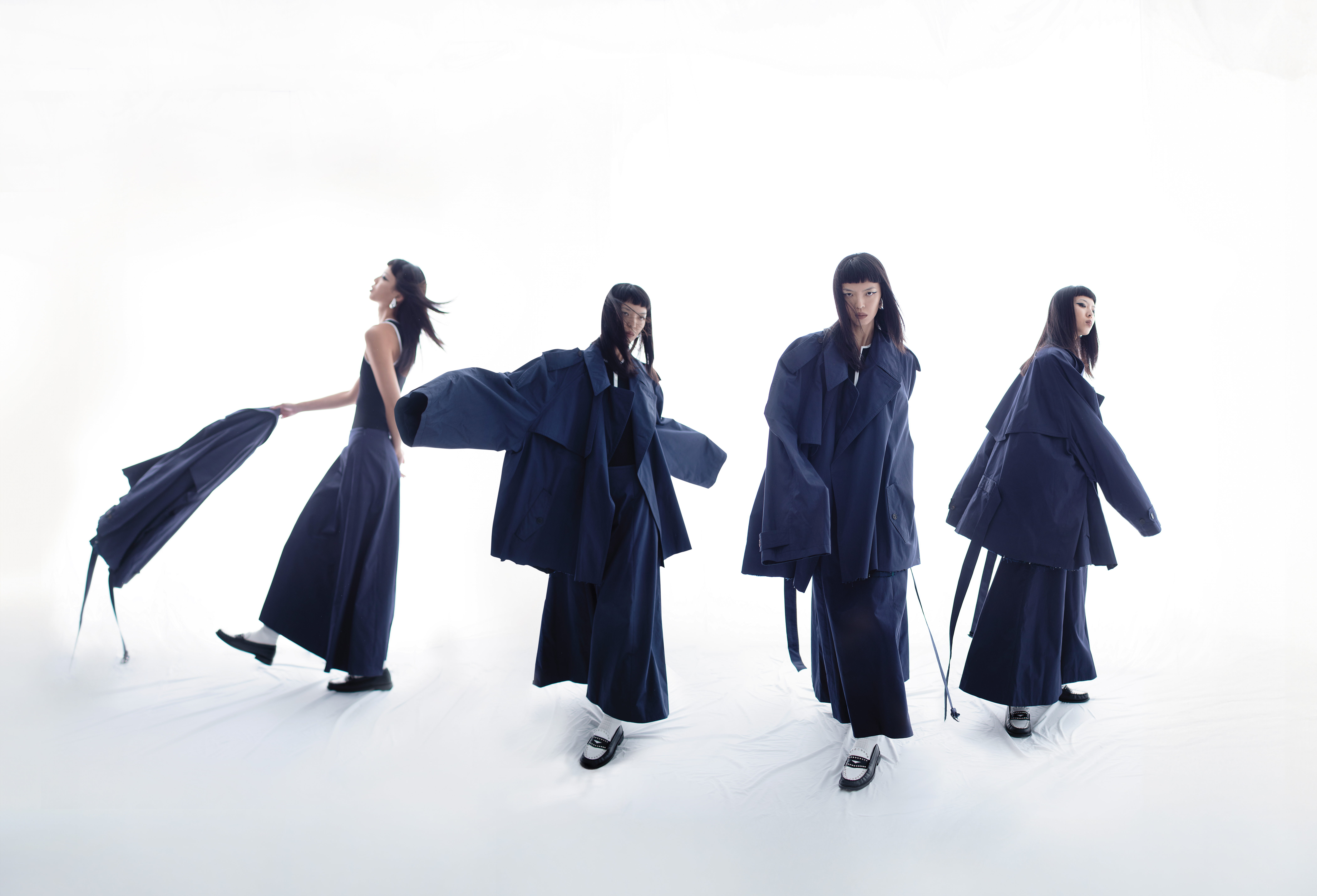 深藍色風衣，價格店洽，BALENCIAGA；拉鍊運動連身服，NT$7,690，Maje；深藍色長裙，價格店洽，BALENCIAGA；黑白色樂福鞋，價格店洽， Sandro；銀色耳環，NT$12,900，Tory Burch。