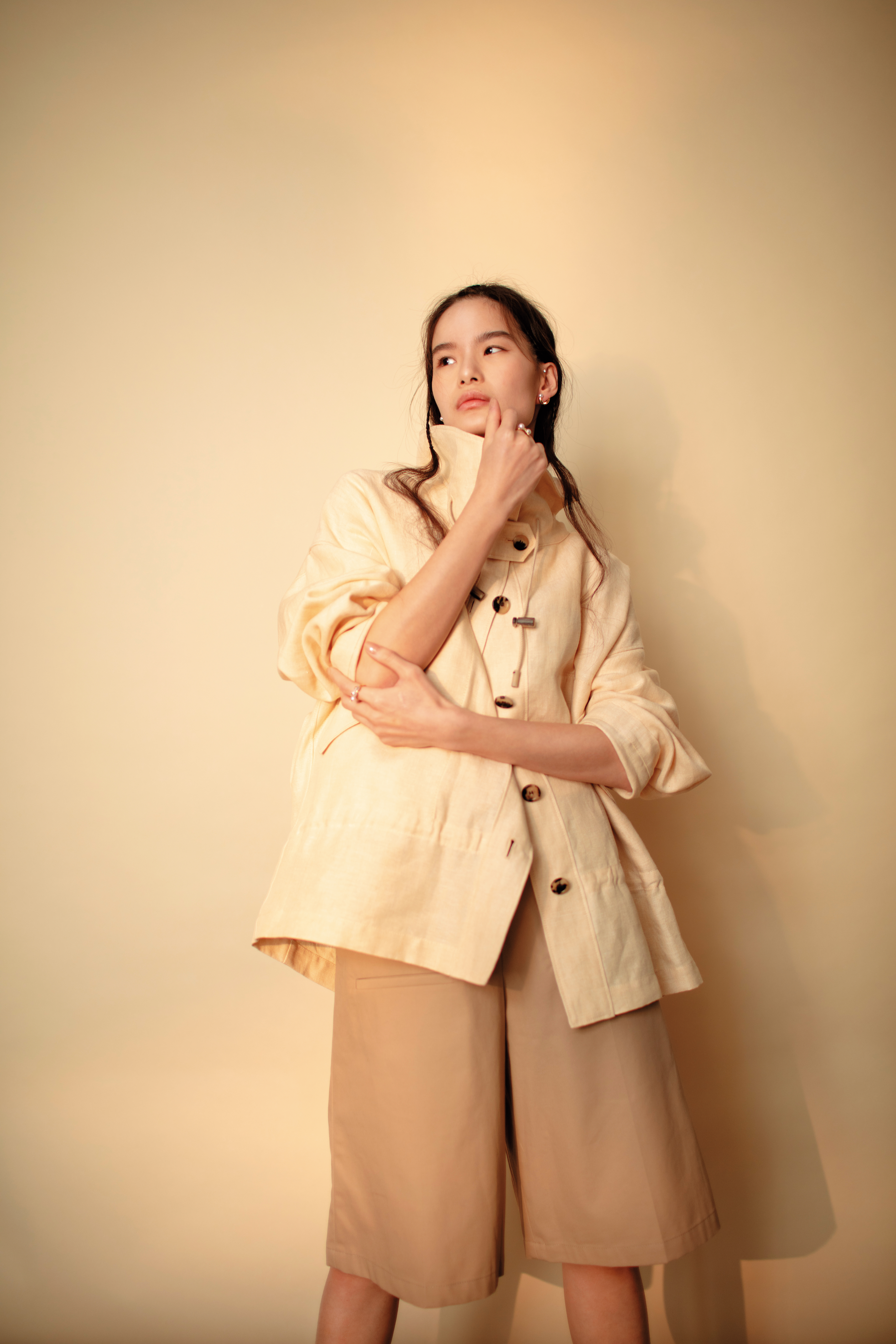 卡其色五分褲 價格店洽 by LOEWE／DOMINICK外套 NT$106,200 by Loro Piana／danger horn耳環 NT$115,000 by TASAKI／（上）danger戒指 NT$102,000 by TASAKI／（下）danger neo戒指 NT$91,200 by TASAKI
