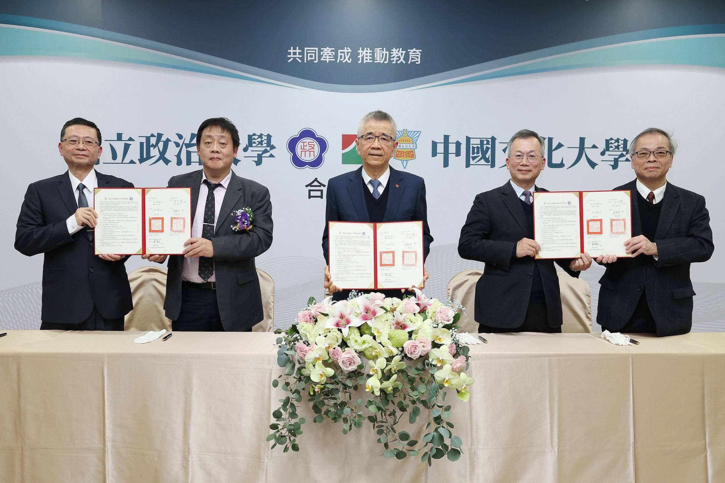 信義企業集團創辦人周俊吉(中)與中國文化大學、政治大學三方簽約合作授課。(信義房屋提供)