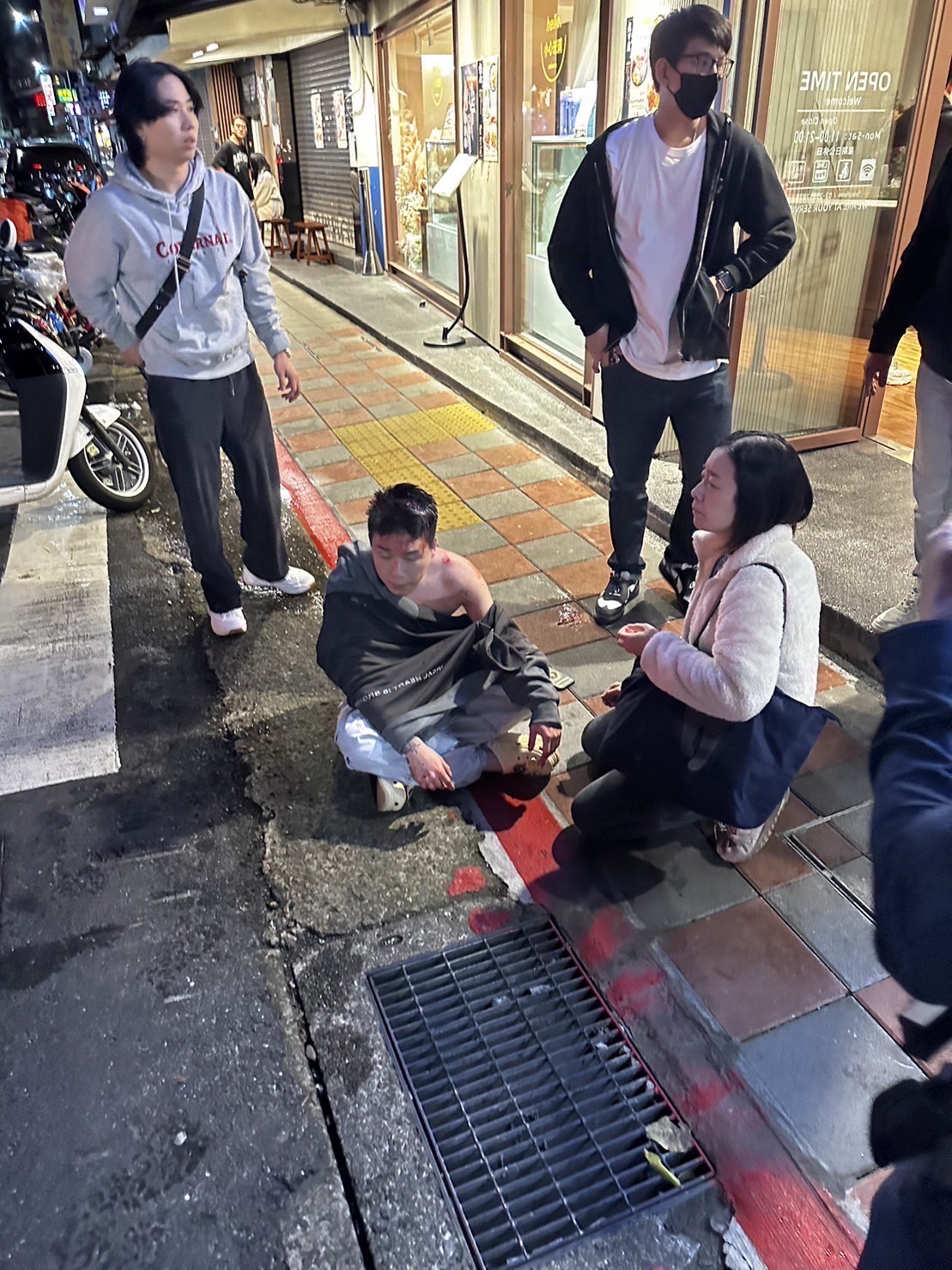被暴打後，Toyz狼狽地坐在街邊。（翻攝自記者爆料網）