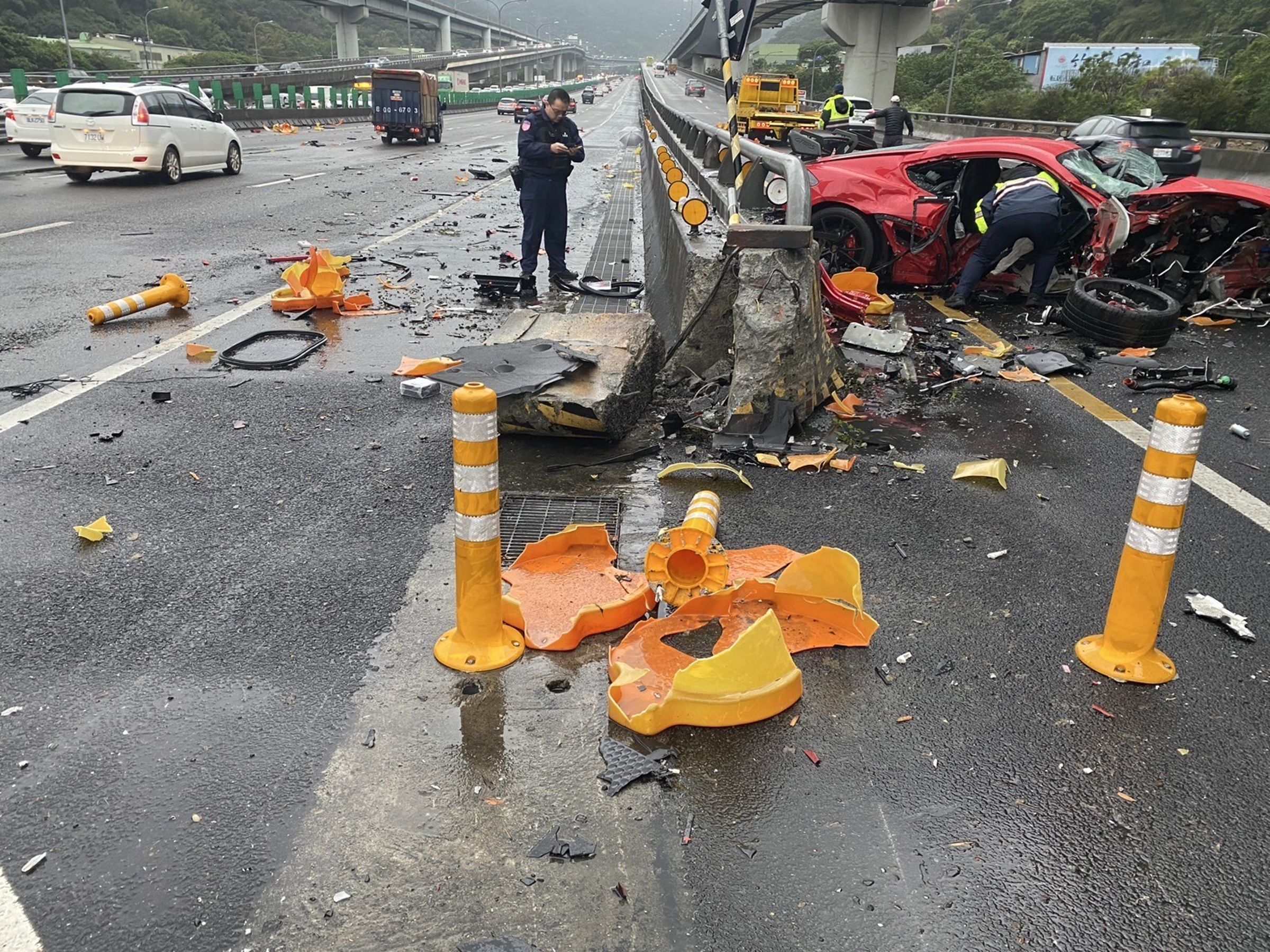 警消將梁男及乘客送往醫院急救；自撞事故造成水泥分隔島也被撞毀。（翻攝畫面）