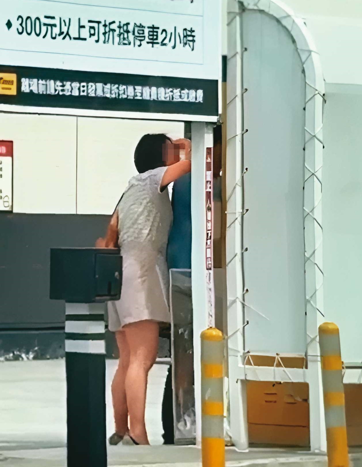 繳停車費時,K女(左)與L男(右)貼得很近,狀似親密。(讀者提供)