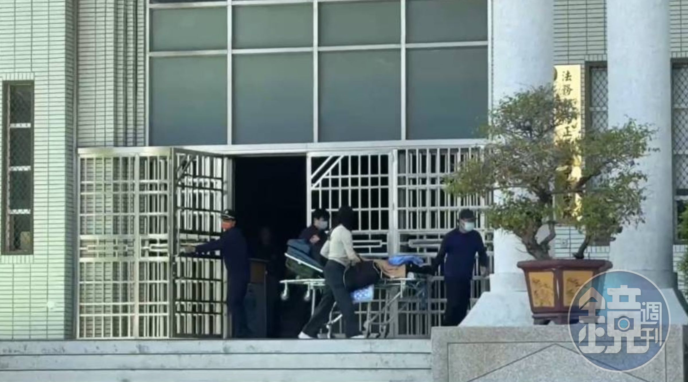 罹患重病的林明佐躺在擔架上,由管理員和家屬推出台中看守所。