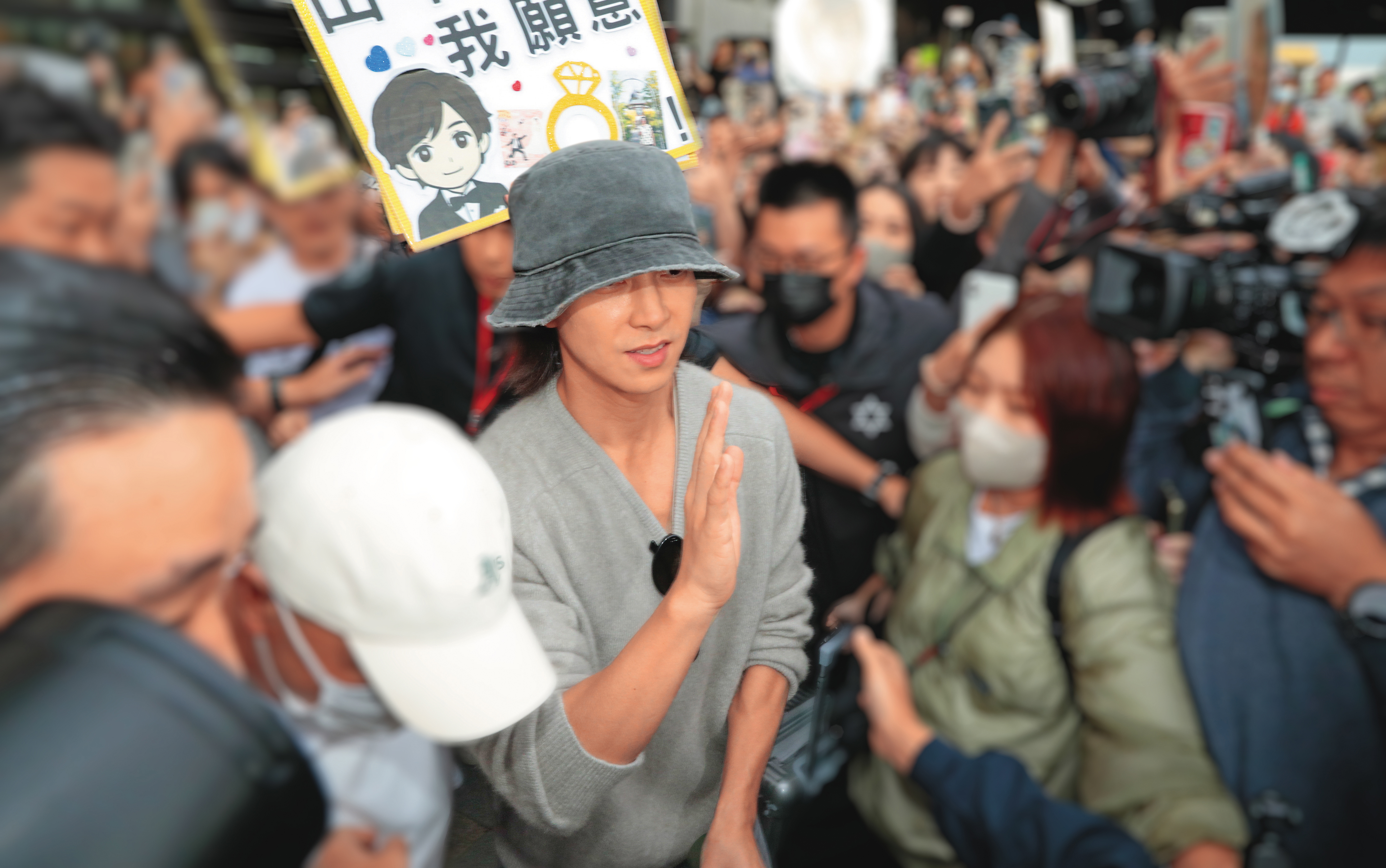 接機粉絲高舉「我願意」看板。不好意思，你願意，小編不願意喔～山P是我的！（推）