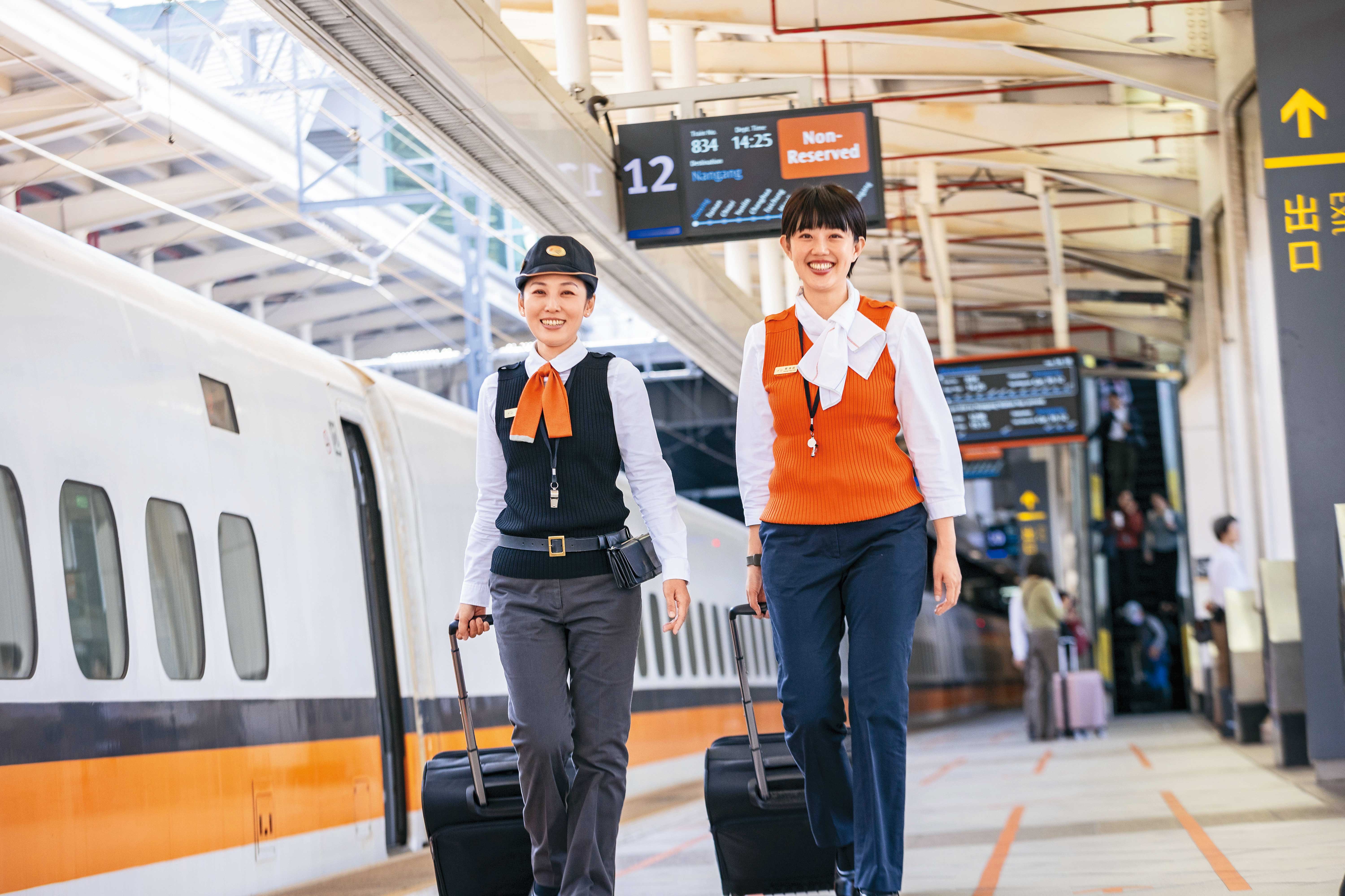 列車長邱芊菱（左）與服勤員覃湘庭（右）拉著手提箱準備登上高鐵列車。