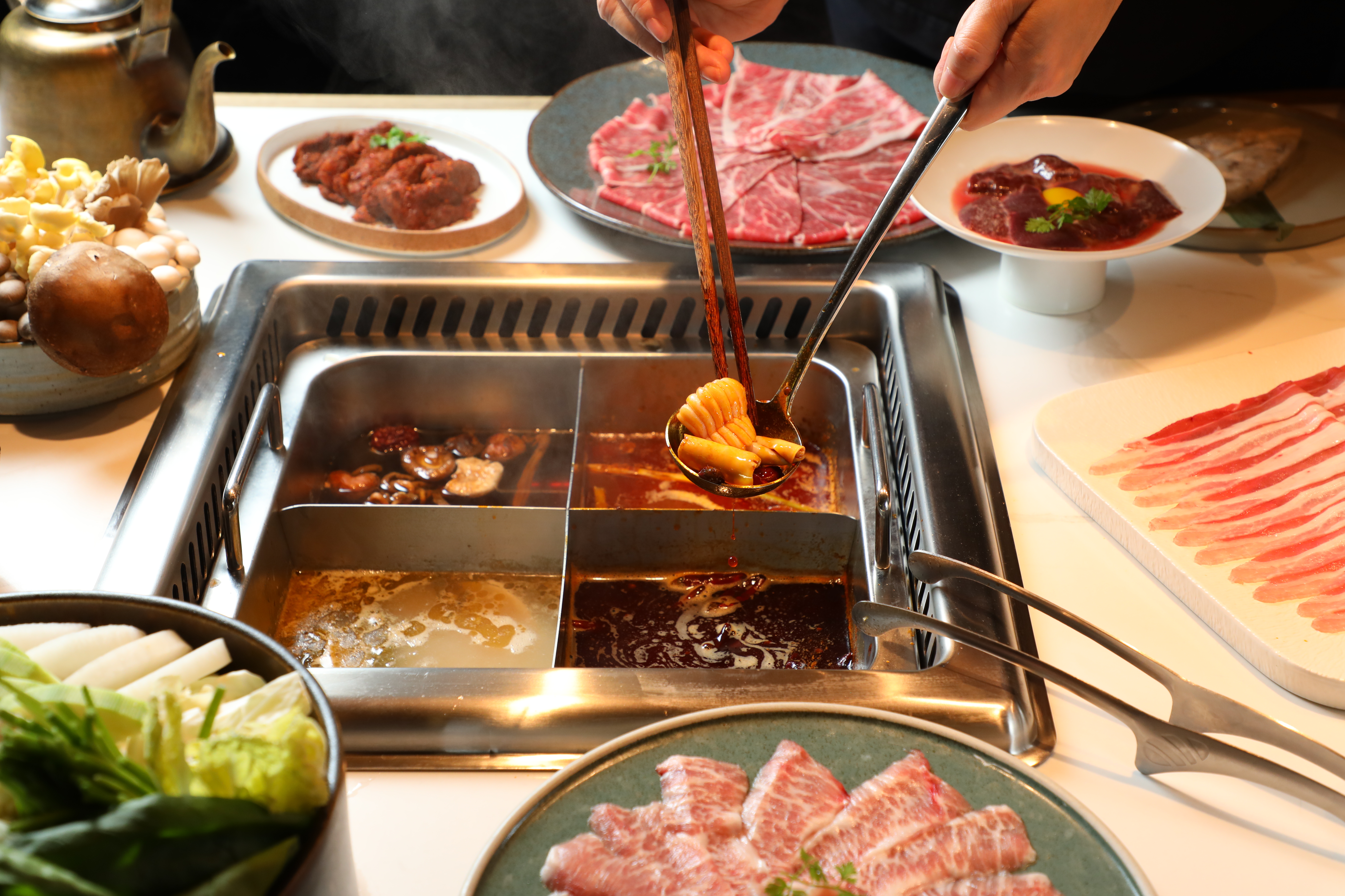 點四宮格可把「重慶牛油鍋」（右下，320元／份）「酸菜魚鍋」（左下，220元／份）「番茄鍋」（右上，240元／份）和「蕈菇鍋」（左上，180元／份）一網打盡。