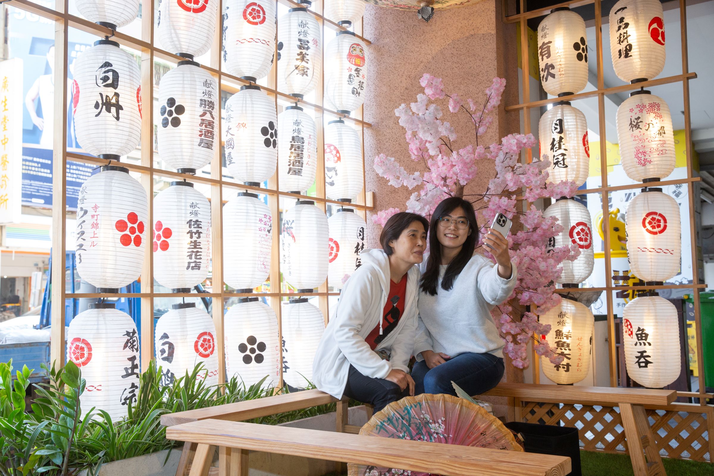 魚吞壽司連店外候客區都設計了日式燈籠、美濃紙傘之網美牆，連等個位都很有戲、充滿氣氛。