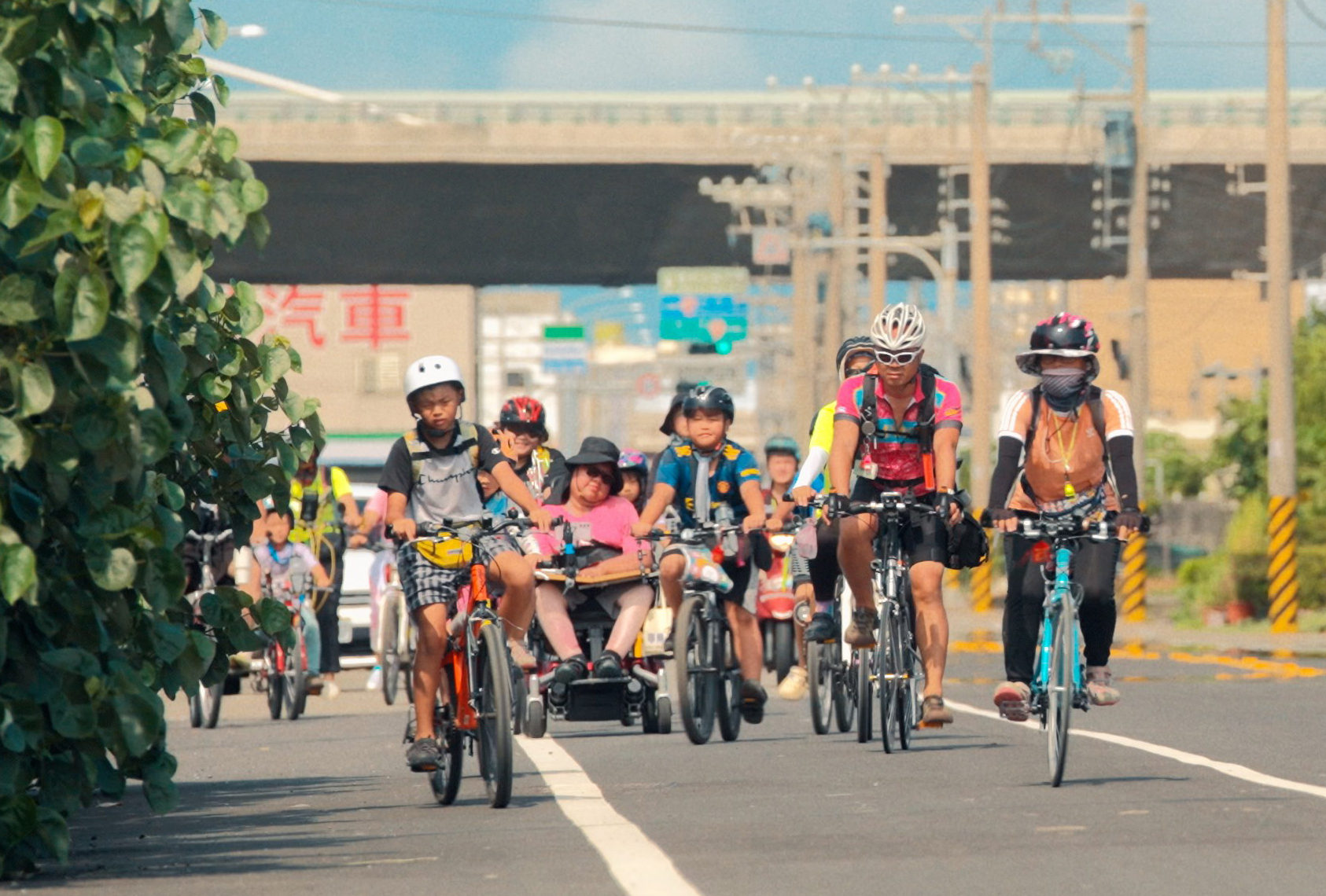 極重度肢體障礙者劉于濟(中)為陪伴兒子參加自學團的「單車環島」儀式,勇敢展開電動輪椅環島。(公視提供)