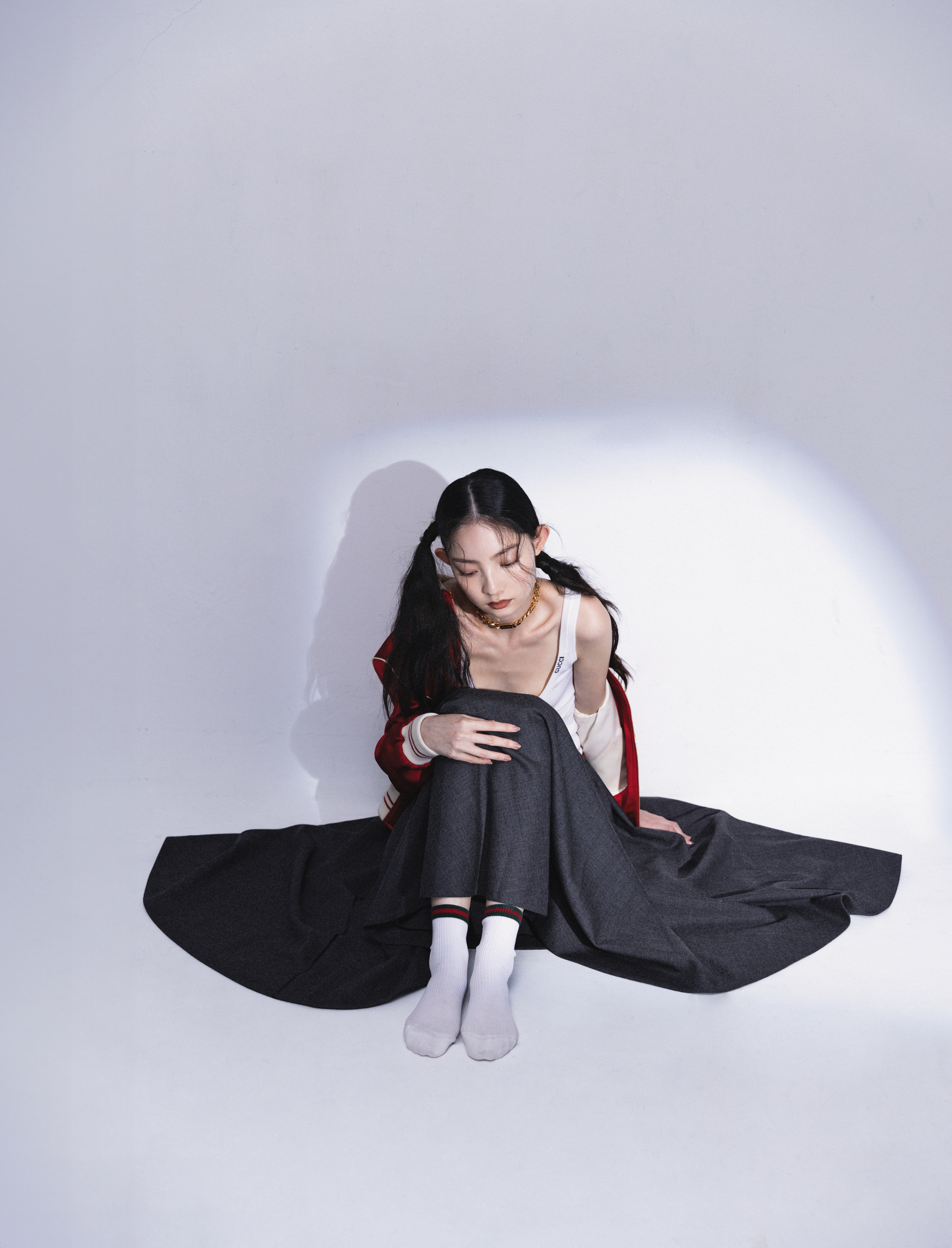 緞面CELINE PARIS TEDDY外套 NT$105,000 by CELINE BY HEDI SLIMANE；白色內搭背心 價格店洽 by GUCCI；灰色長圓裙 價格店洽 by GUCCI； 金色頸鍊 NT$47,900 by GUCCI；綠紅綠短襪 價格店洽 by GUCCI。