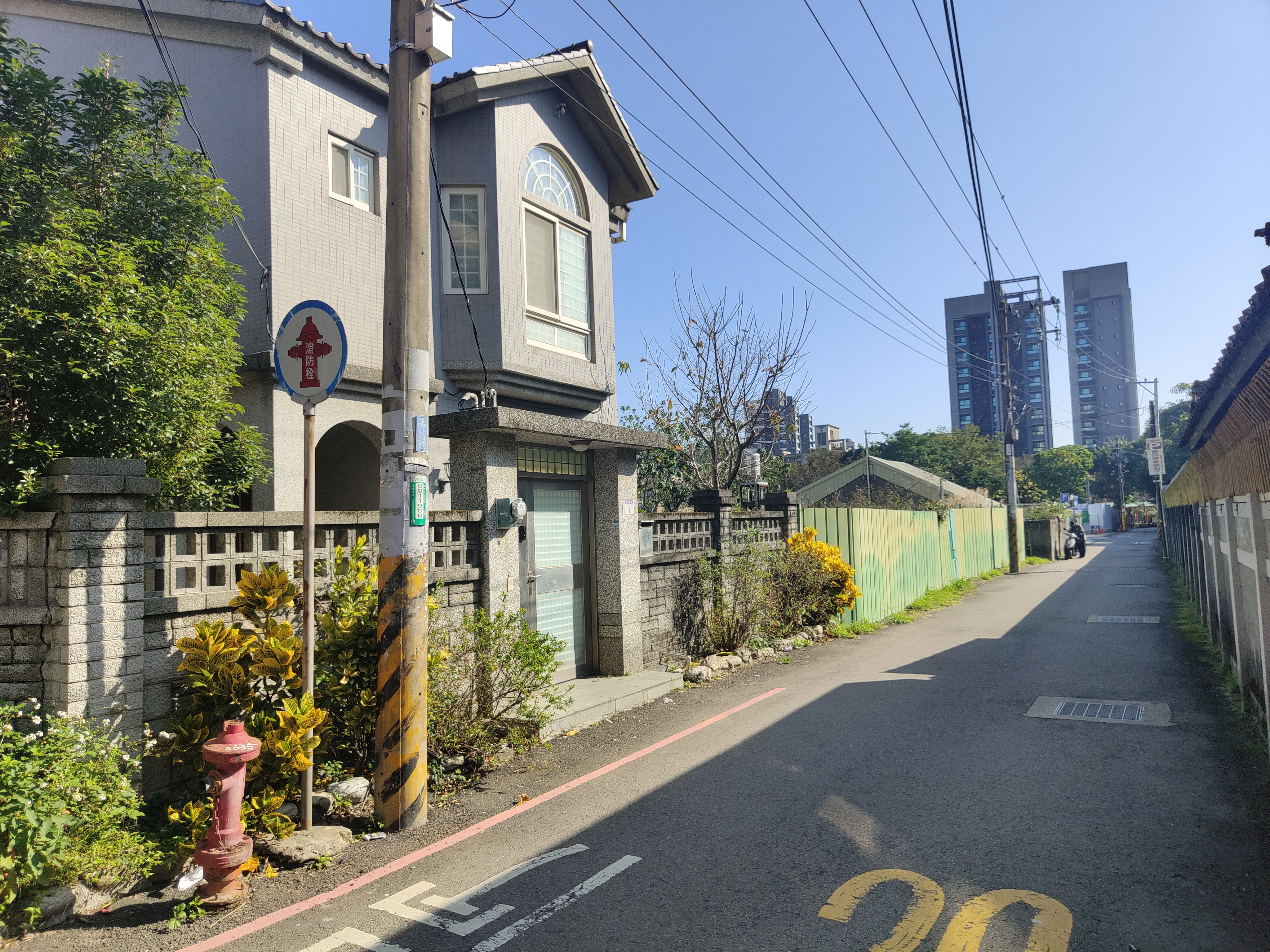 張晉源老家現為3層樓透天厝,還有庭園圍牆,緊鄰的則是已被拆光的空地及待拆平房。