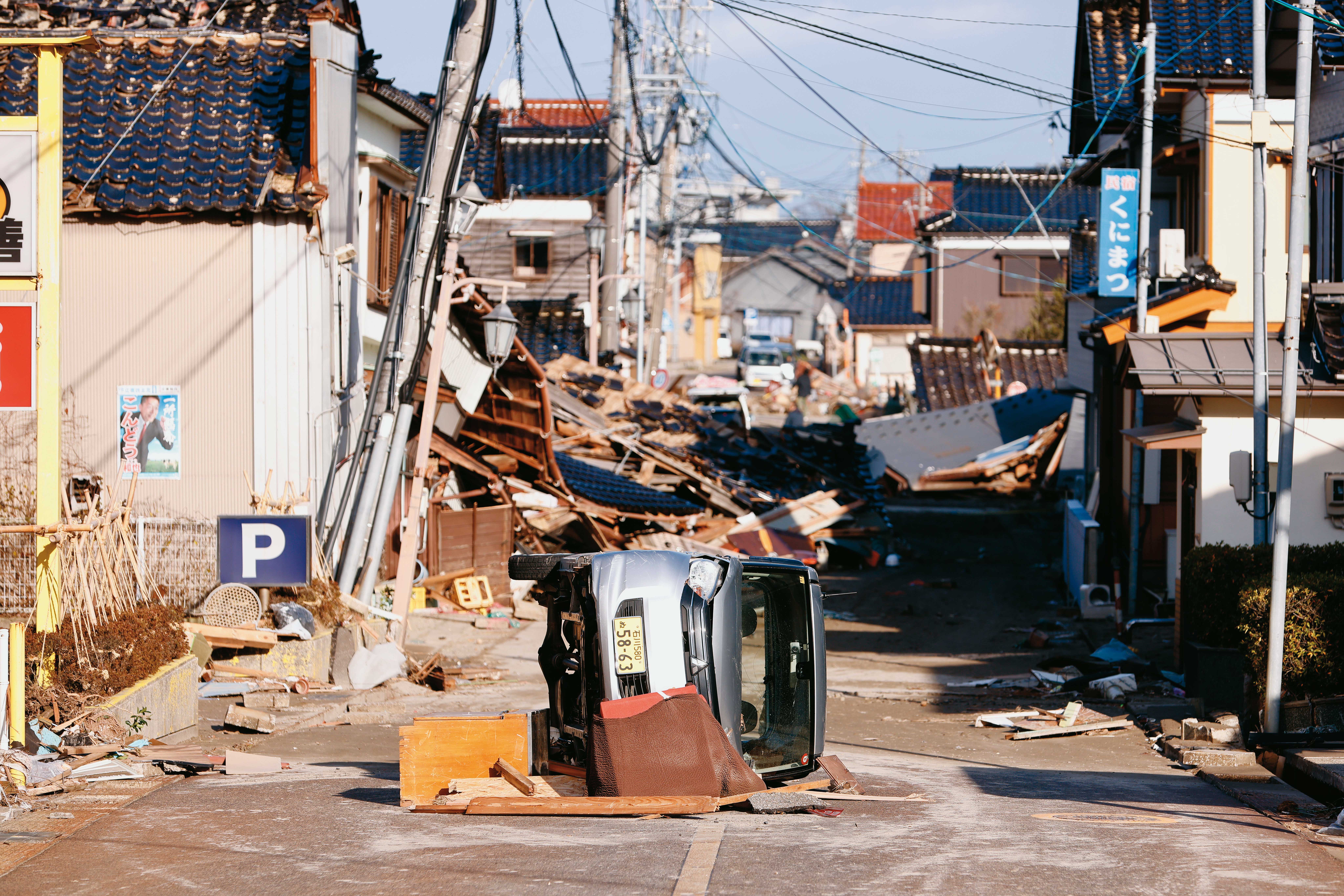珠洲市在地震發生後，沿海的吾妻町一帶遭受海嘯侵襲，海嘯將一台車子沖倒翻覆在路中央。