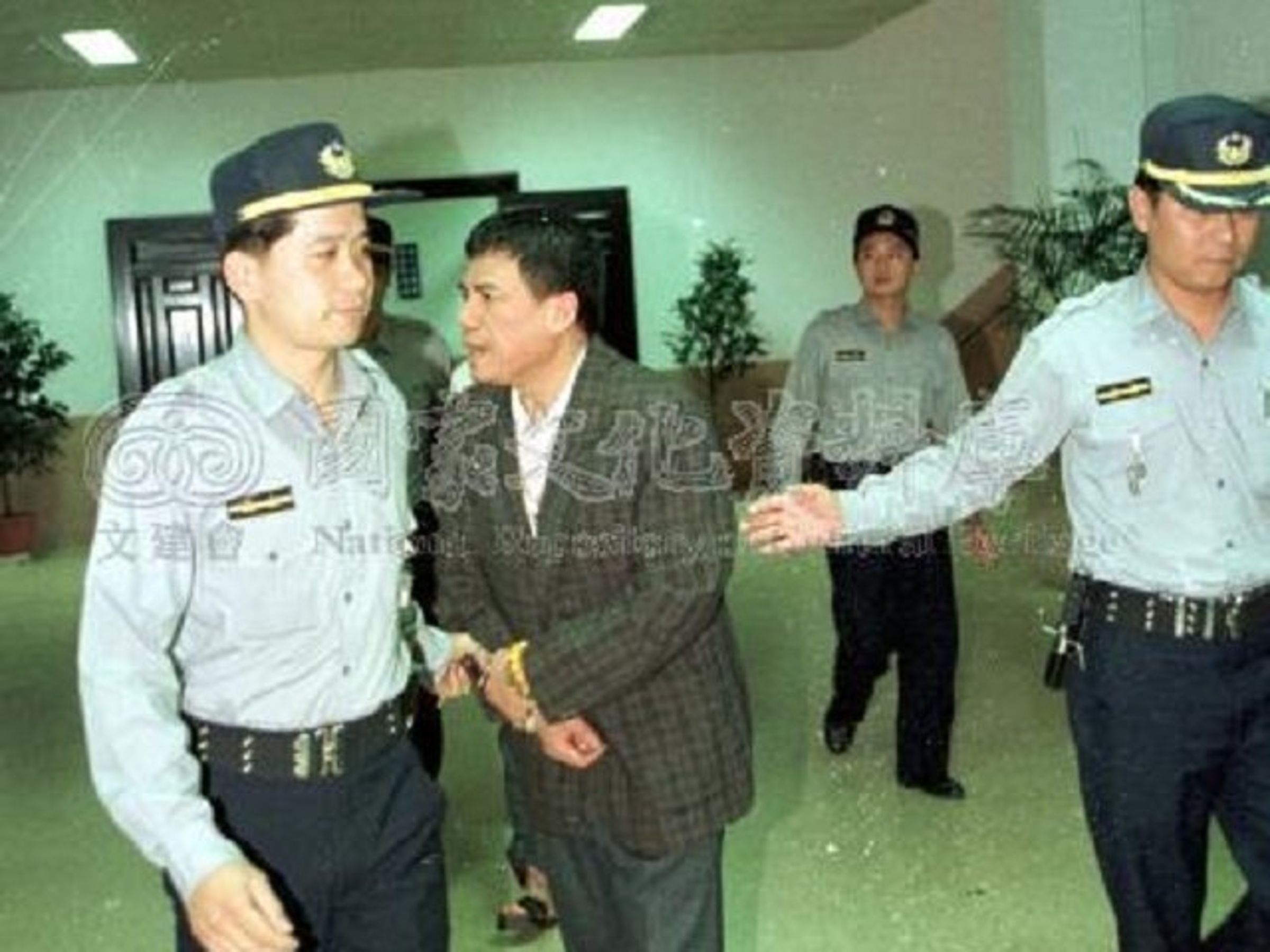 電玩大亨周人蔘(著深灰色西裝者)逝世！叱吒90年代，創史上最大規模檢警貪污案。（翻自國家文化記憶庫）