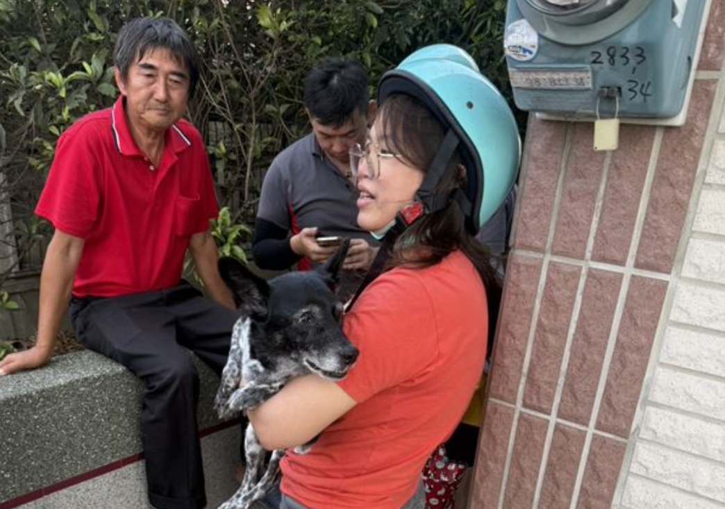 陳小姐抱起失而復得的陳美琪感動落淚，一旁為尋獲狗狗的廖姓阿北。（翻攝畫面）
