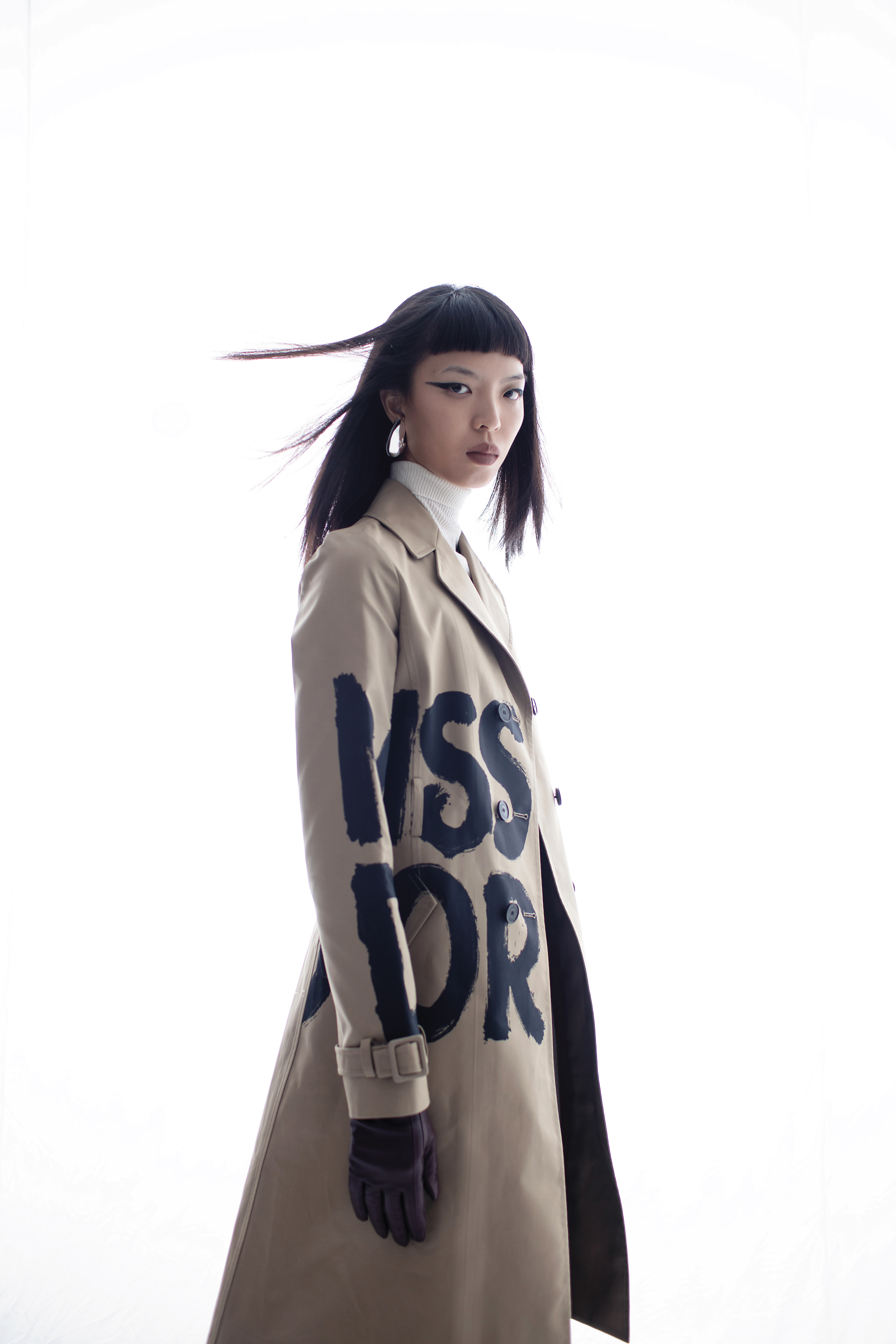 塗鴉風衣，NT$270,000，Dior；白色高領上衣，價格店洽，Maje；銀色耳環，NT$12,900，Tory Burch；酒紅色皮革手套，價格店洽，Maje。