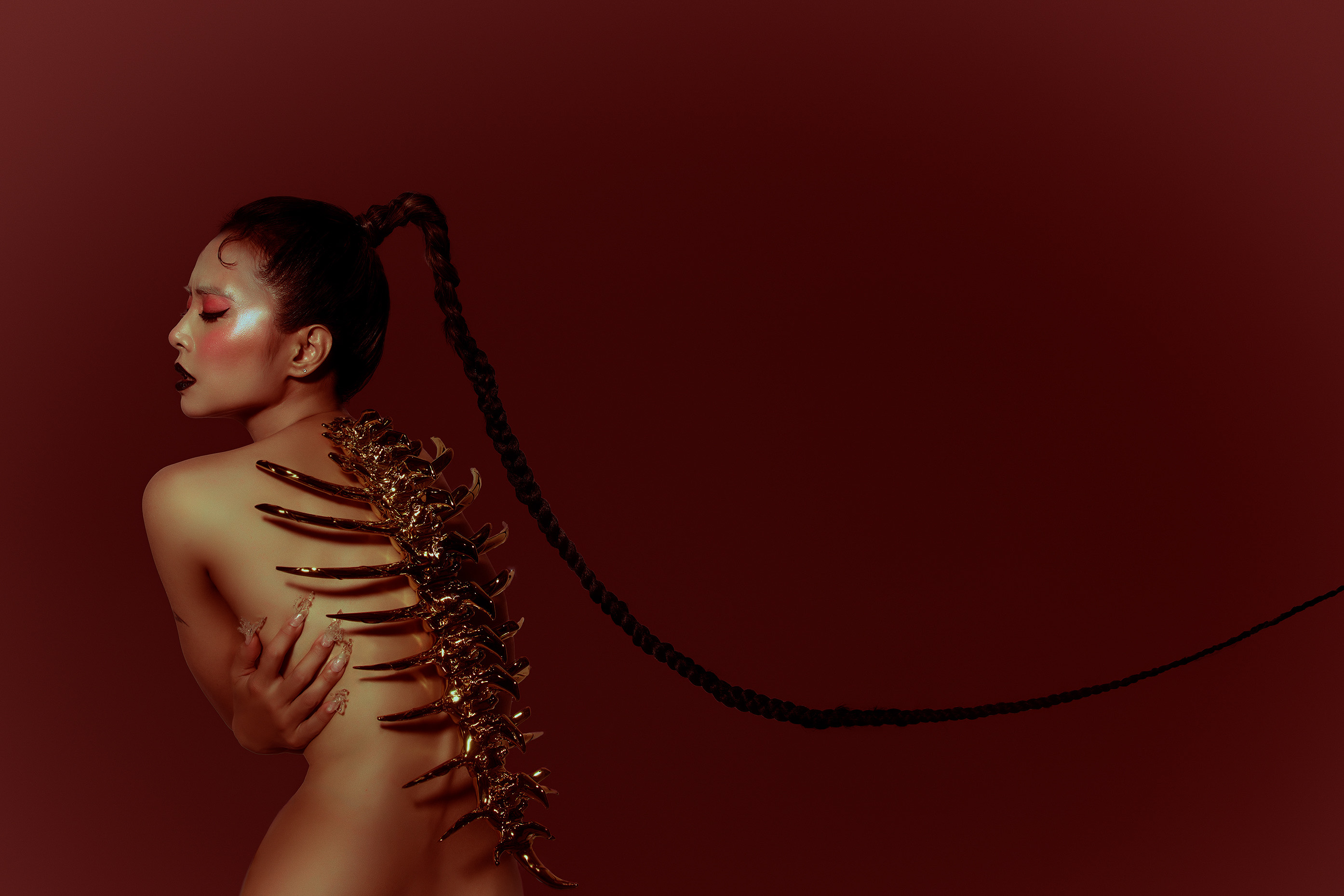 JOLIN 以背影入鏡，金屬脊椎如盔甲自背上生長，象徵從脆弱淬鍊出的堅韌與蛻變。（凌時差音樂提供）