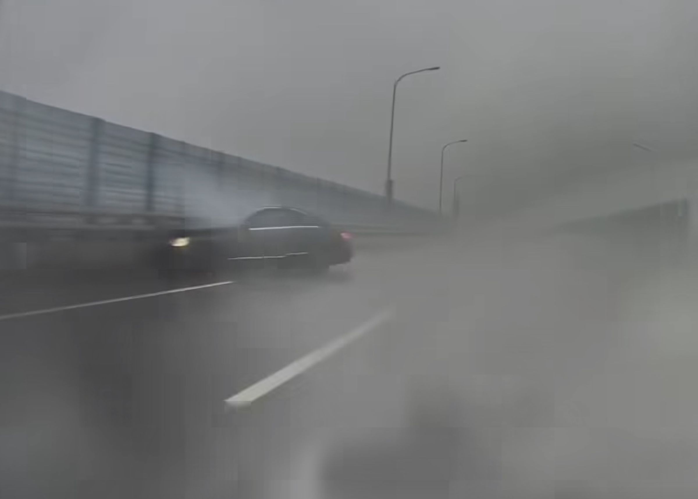 賓士駕駛在發現後車無意「對戰」後似乎自行加速駛離,熟不知一分鐘後,該輛賓士在積水彎道路段打滑失控,自撞外側護欄。(翻攝「爆料公社」)