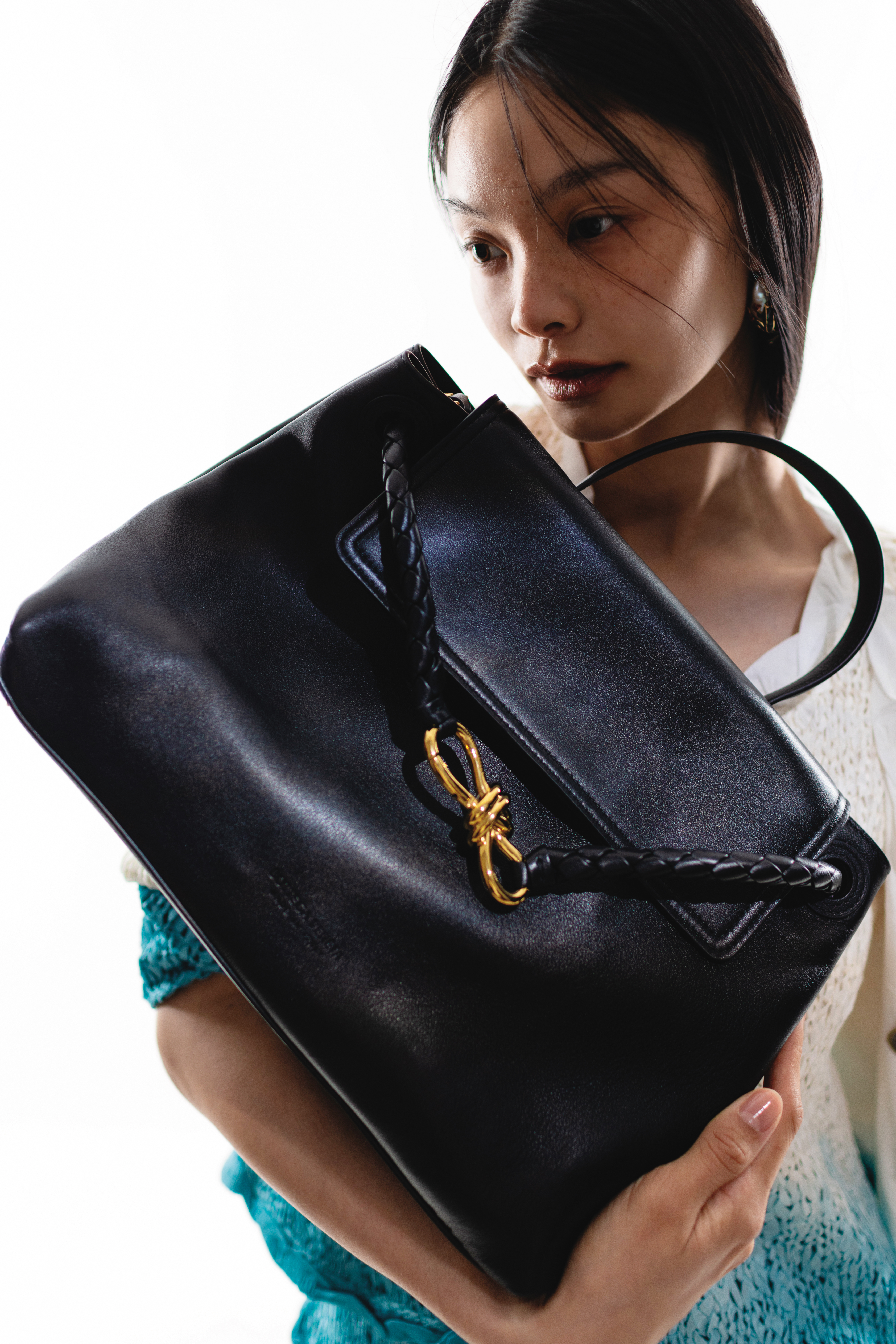 Ciao Ciao絲滑皮革手提肩背包NT$186,900 by BOTTEGA VENETA；混色編織外套 價格店洽 by BOTTEGA VENETA；混色編織上衣 價格店洽 by BOTTEGA VENETA；青蛙造型耳飾 價格店洽 by BOTTEGA VENETA。