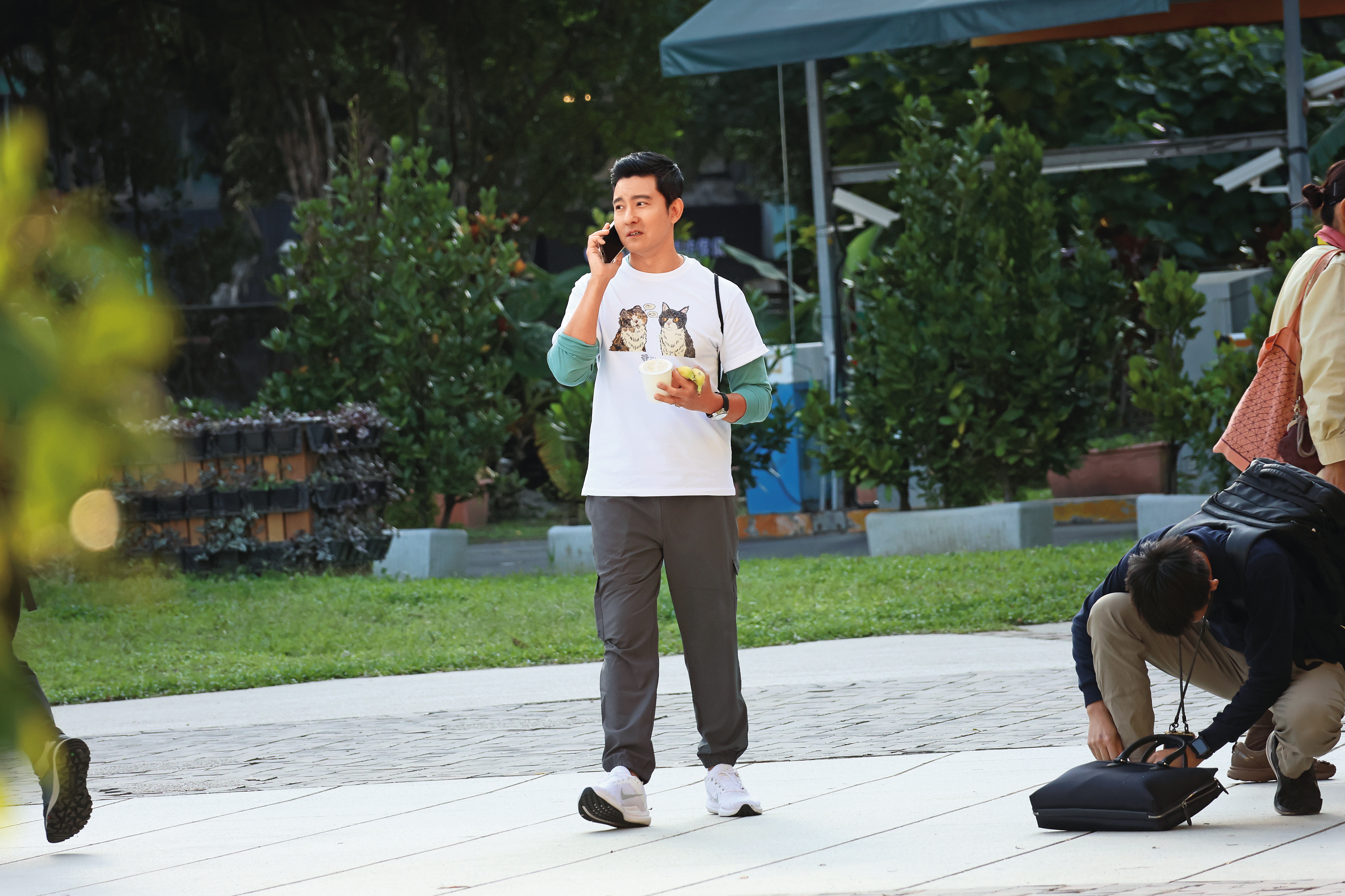 立威廉邊走邊逛，手上還拿著剛買的兩根香蕉，同時接起了電話。