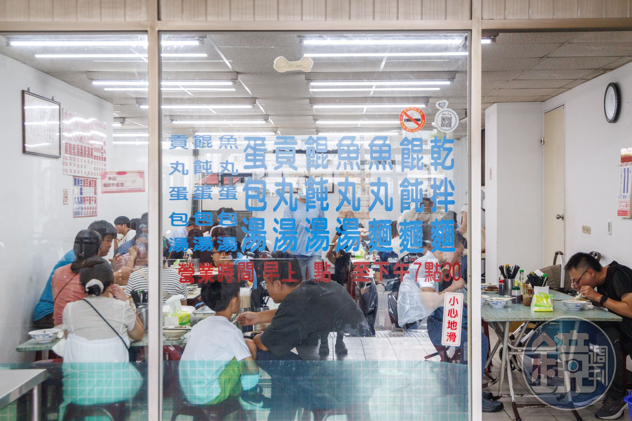 典型的台灣麵店門面,玻璃門上貼著菜單。