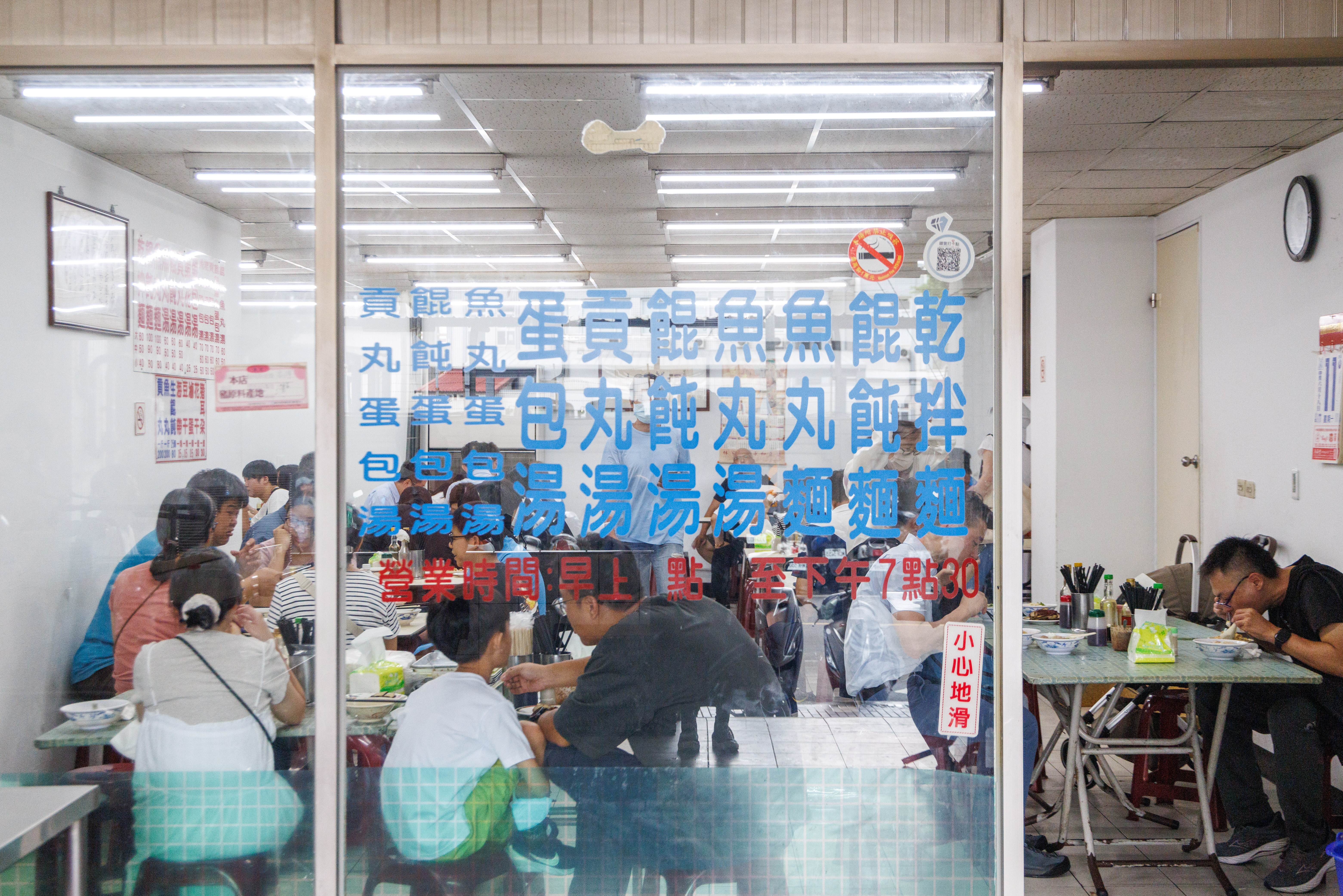 典型的台灣麵店門面,玻璃門上貼著菜單。