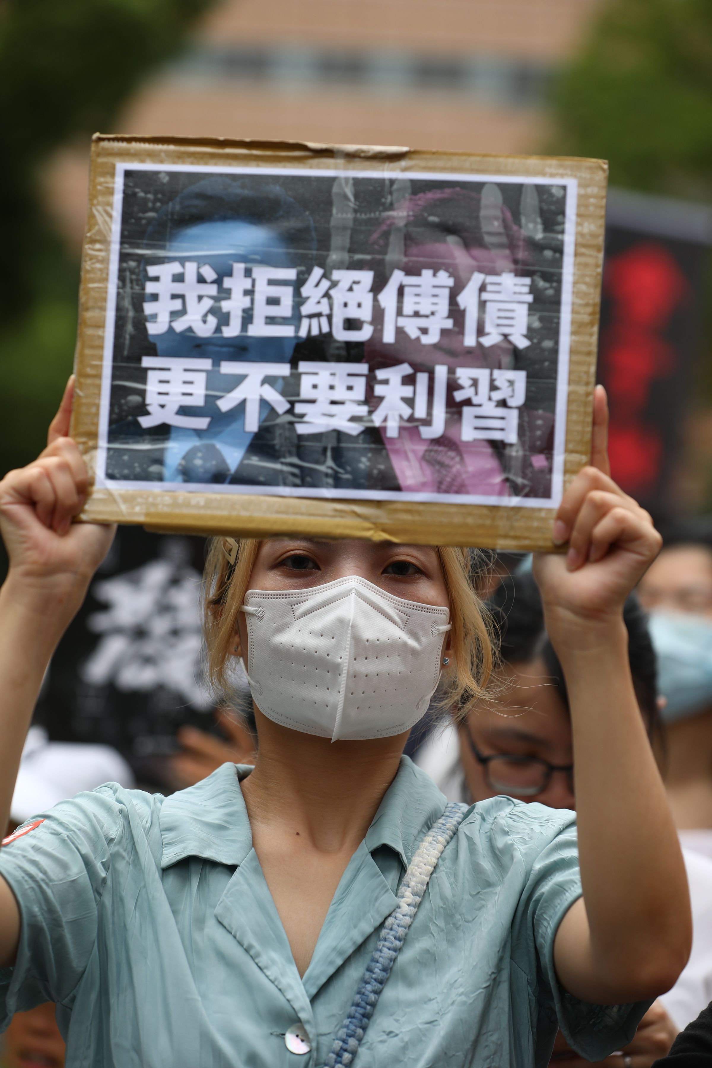 民眾舉著雙關的標語抗議。