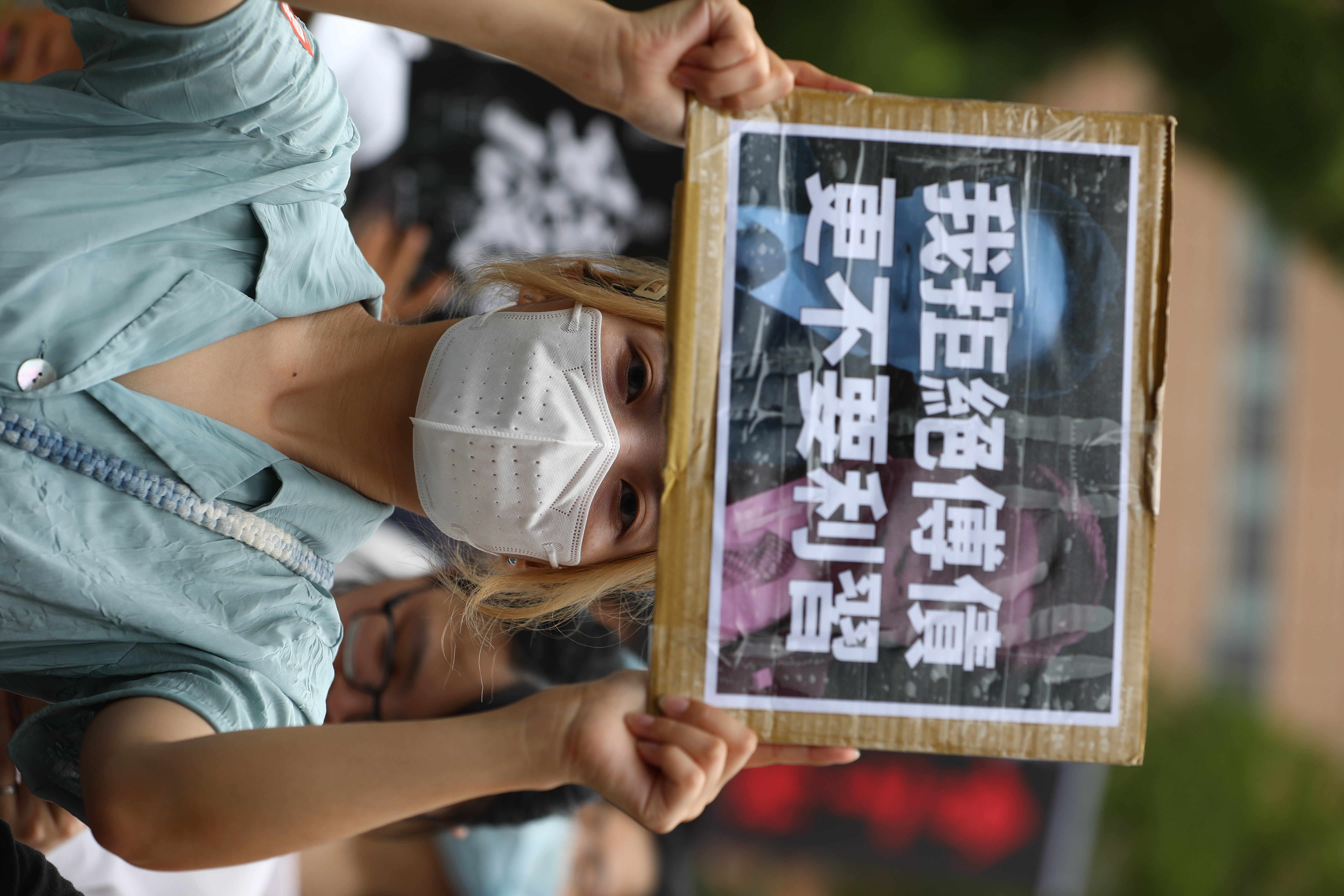 民眾舉著雙關的標語抗議。