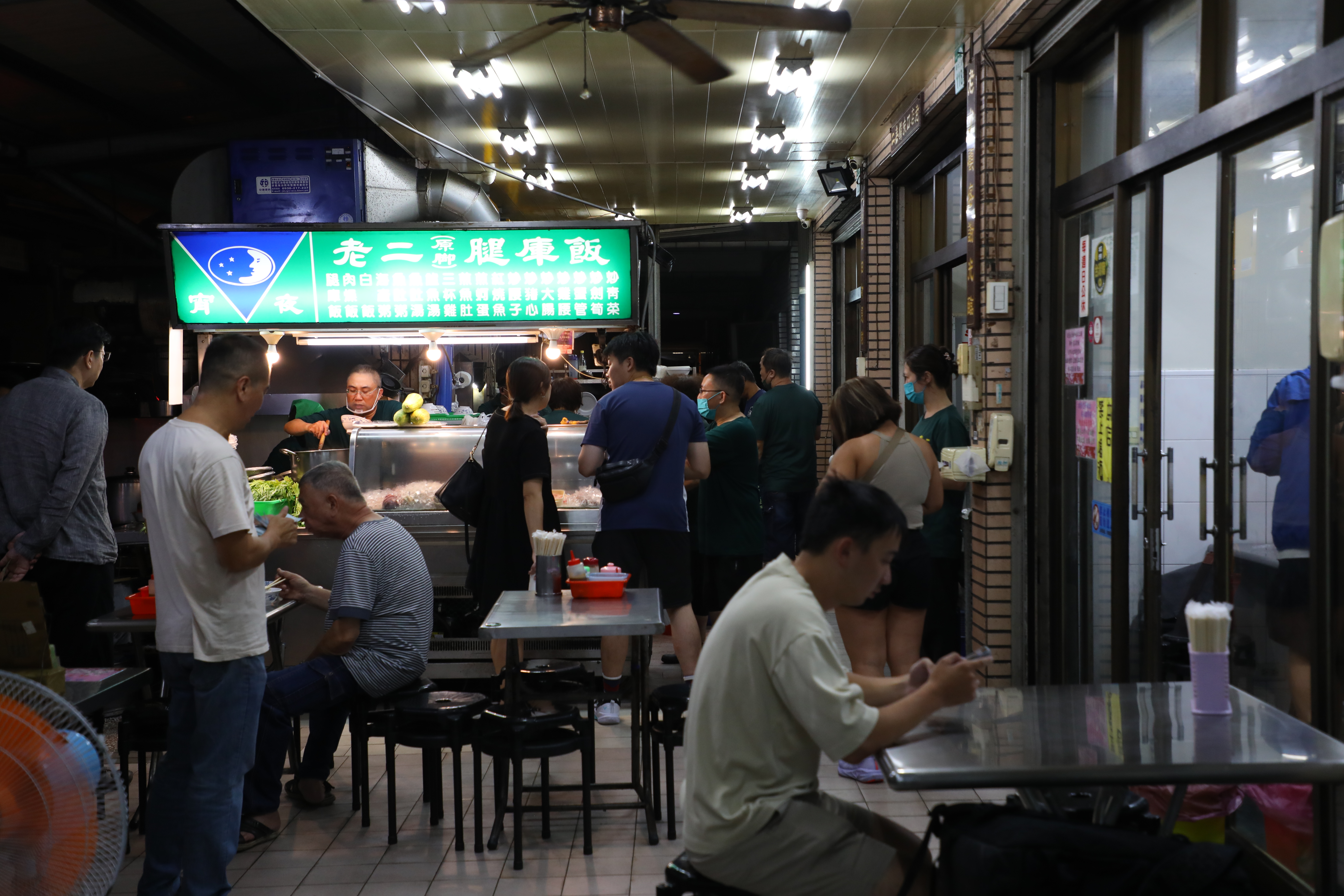深夜時分,在騎樓下開店的老二腿庫飯人潮川流不息。
