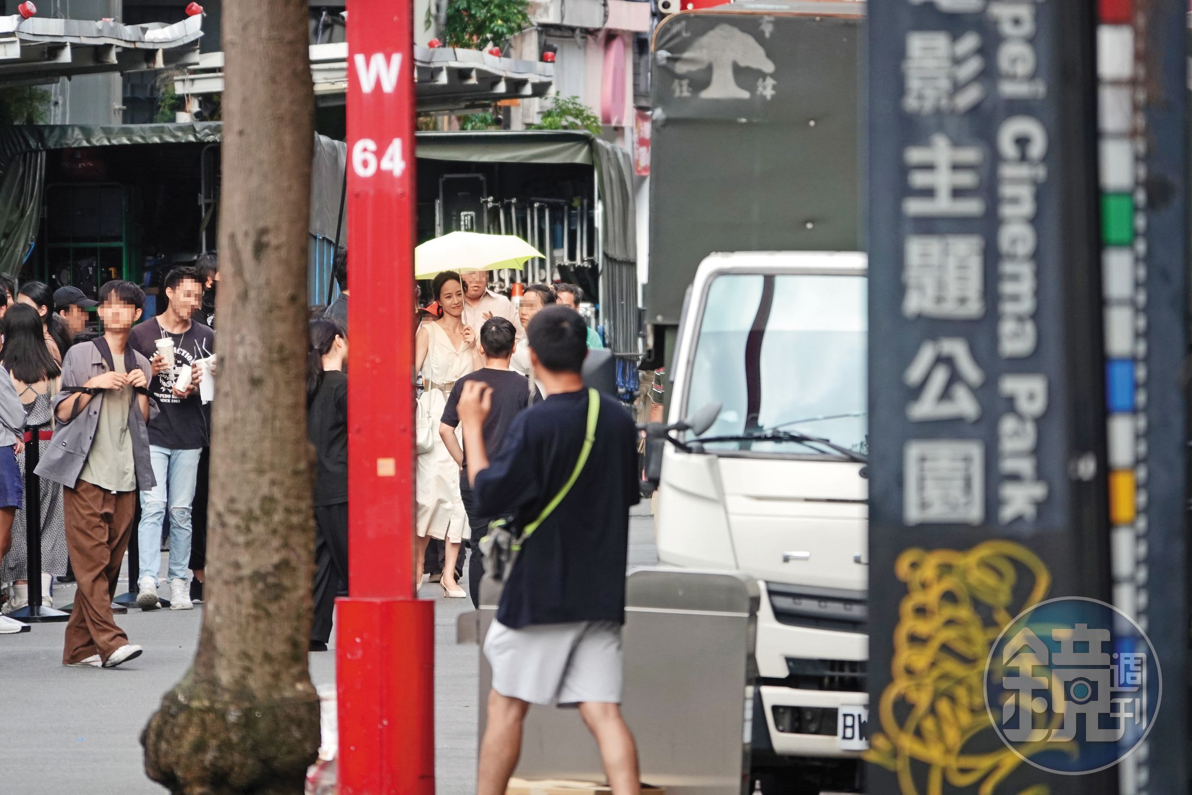 8/12 15：27 撐著傘的張鈞甯與周渝民對戲，現場一喊卡，助理趕忙上前梳化、補妝外加擦臉，張鈞甯笑得很開心。