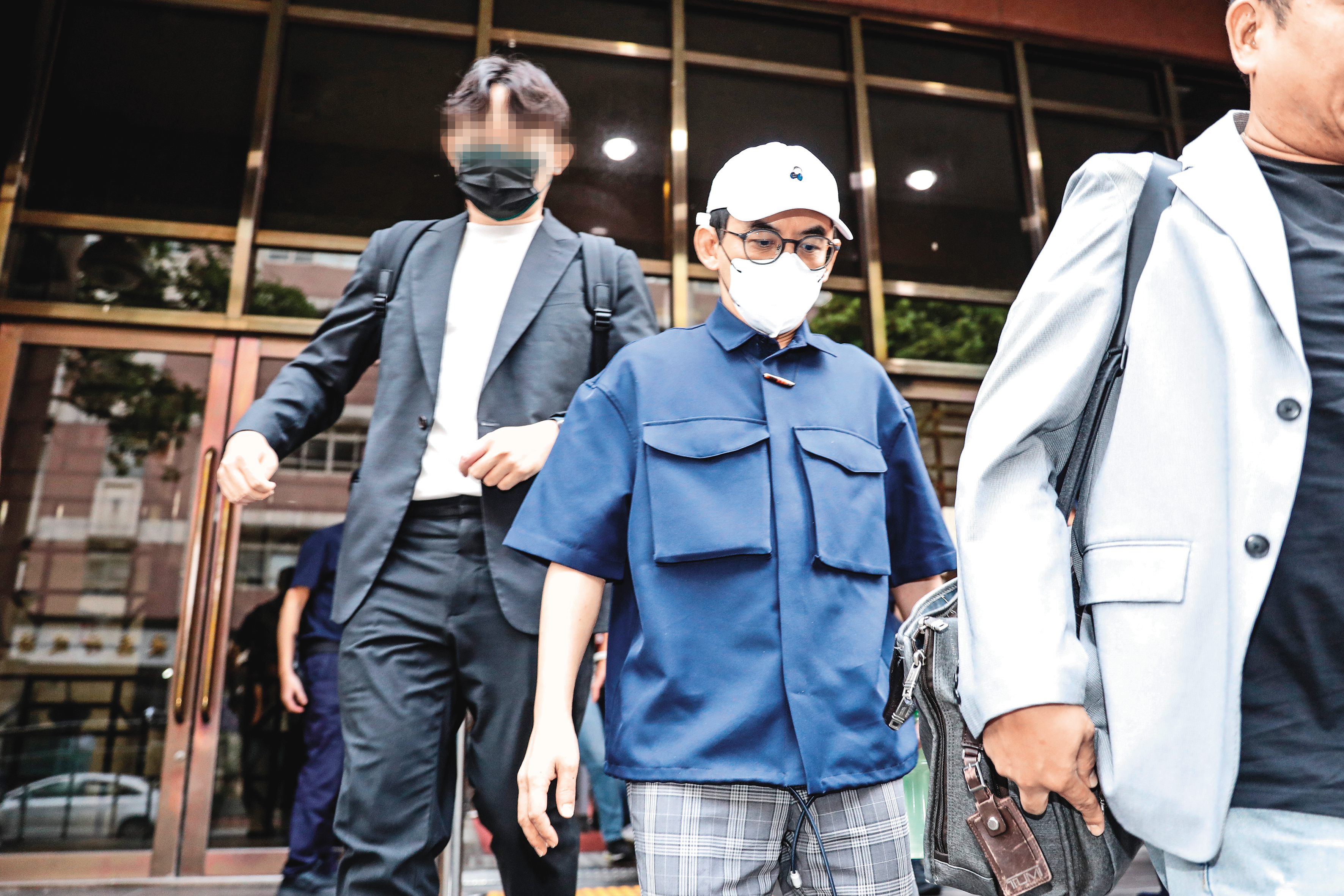 黃子佼（中）出庭時，幾乎都穿著同一件藍色襯衫。
