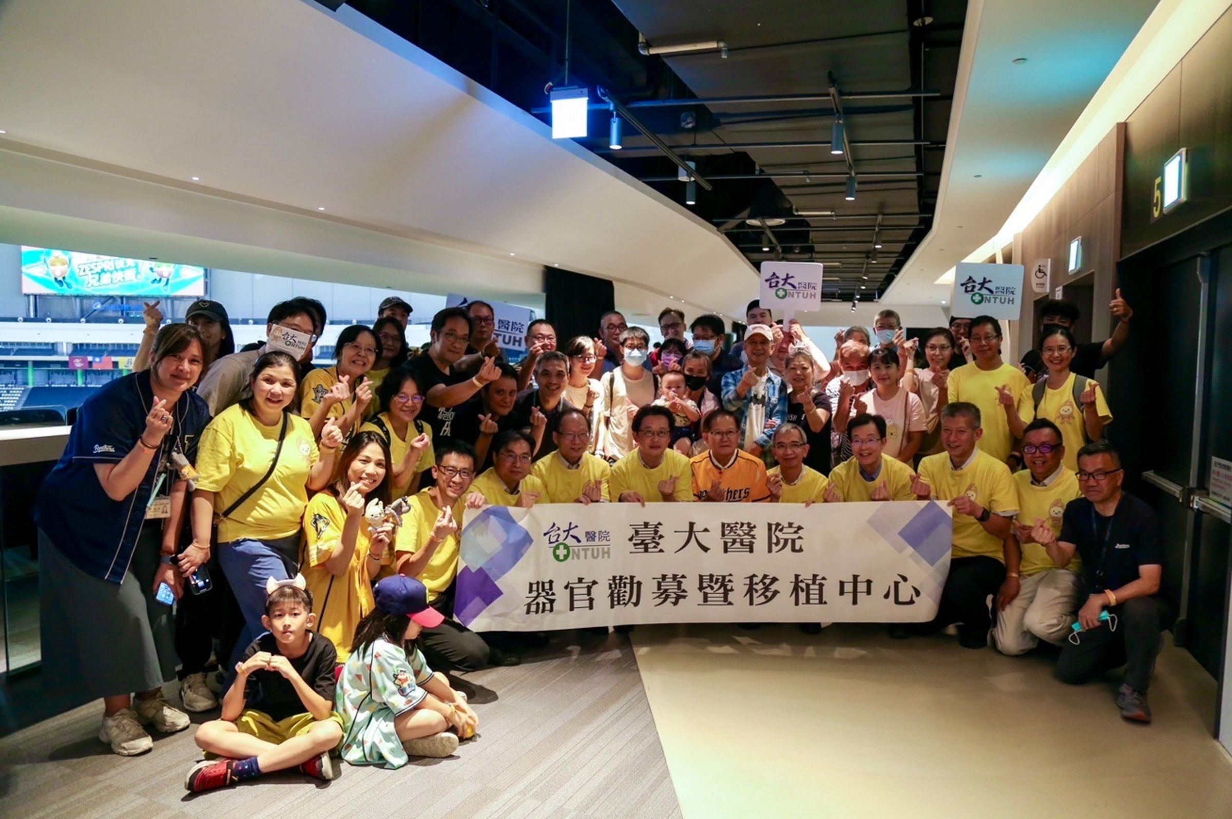 陳國恩(圖中橘衣)與台大醫護人員、台大醫院病友開心替中信兄弟應援。(中信育樂提供)