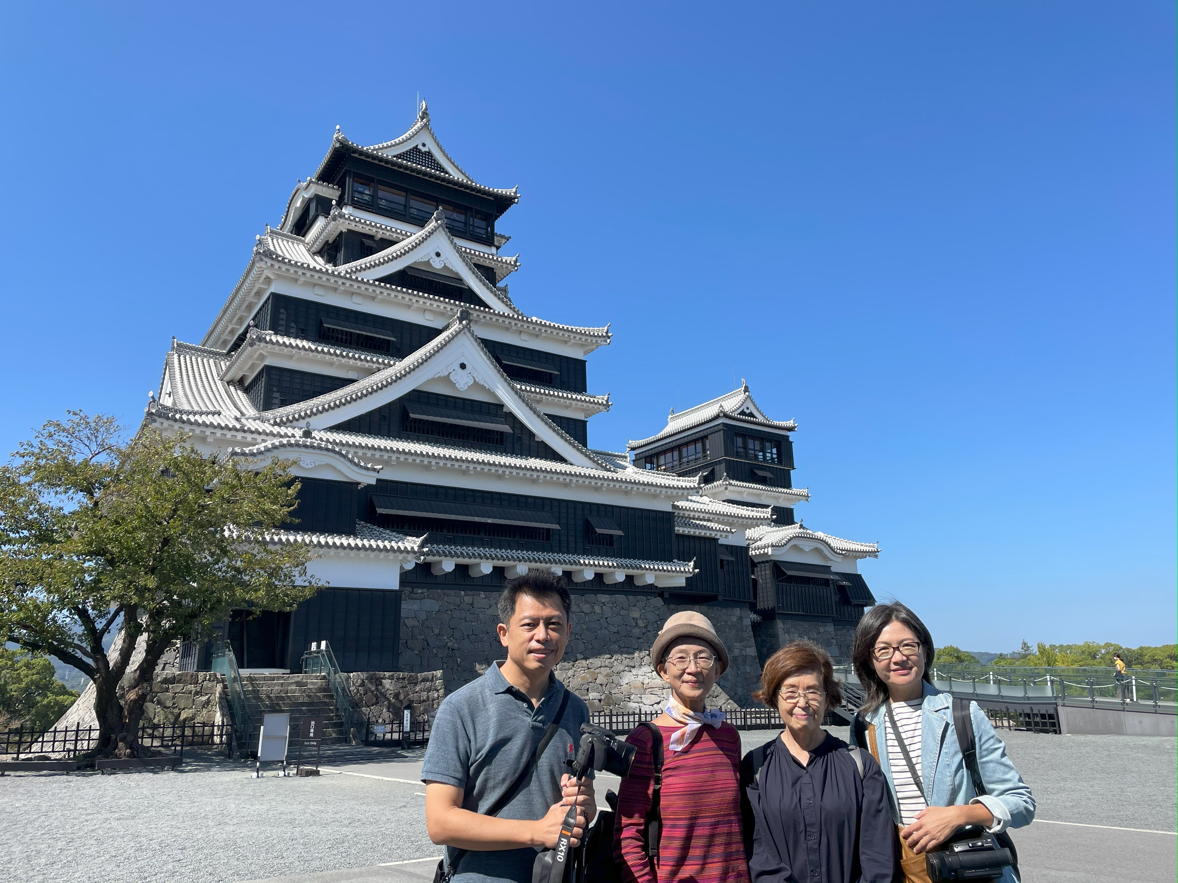 黃銘正(左)和連楨惠(右)赴日本拍攝,與湯聰模的女兒湯雅清(左二)和表妹水上裕子(右二)在熊本城前合影。(希望行銷提供)