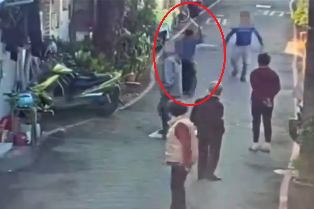 林男（紅圈）不滿鄰居在住家前空地晾衣服，竟持刀劍揮舞追砍。（翻攝畫面）