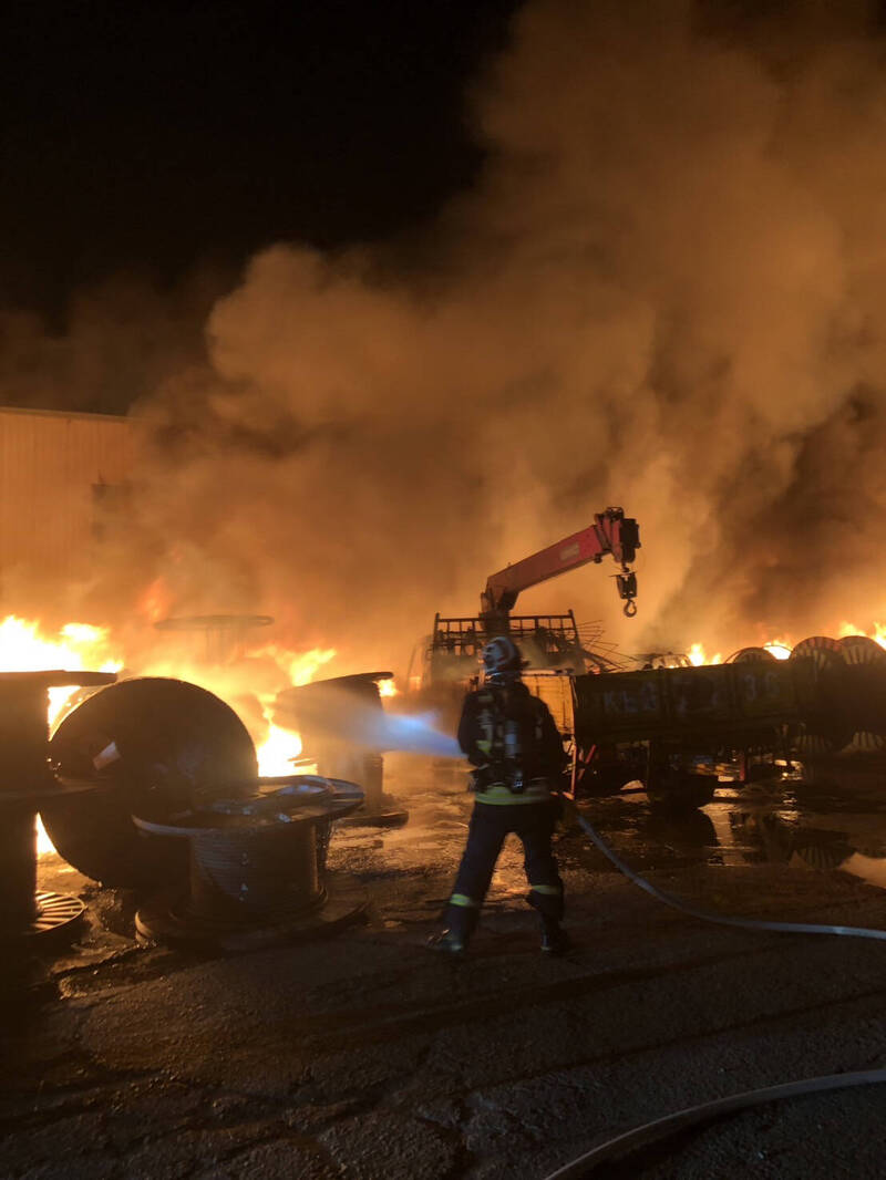 工廠一樓鐵皮屋付之一炬，戶外空地大量電纜起火燃燒，面積約200平方公尺。（消防局提供）