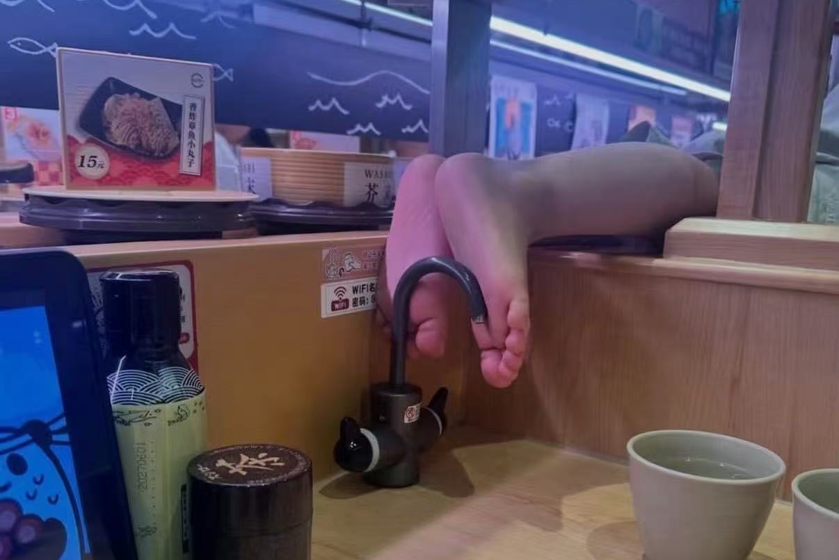 有男童光在中國廣州壽司郎用餐時,光腳跨過隔板踩在水龍頭上。(翻攝自微博)