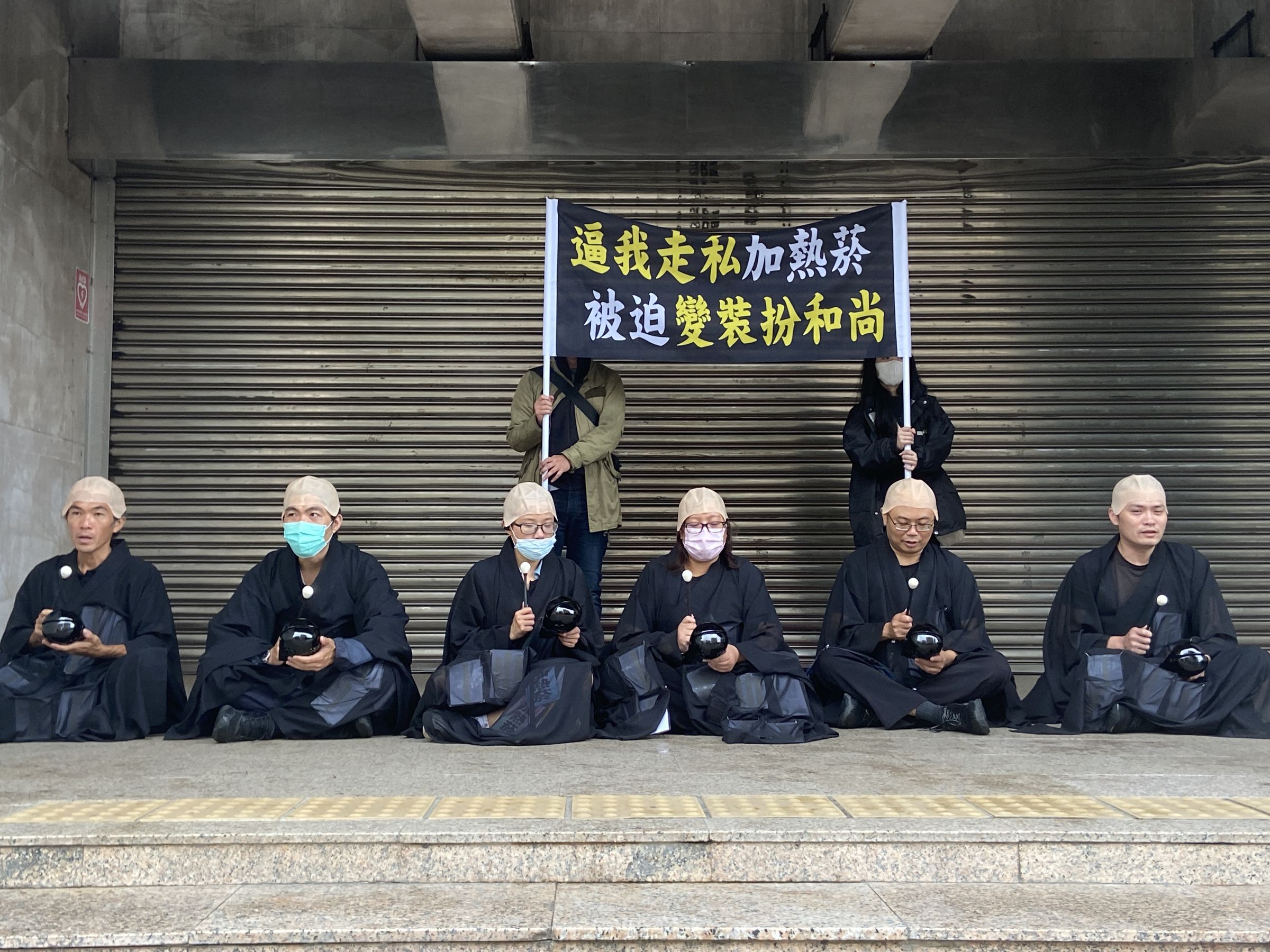 彭華幹號召民團成員扮和尚,海青袈裟內貼滿加熱菸字樣,諷走私入境,水貨商賺進不法暴利。(Clear air大聯盟提供)