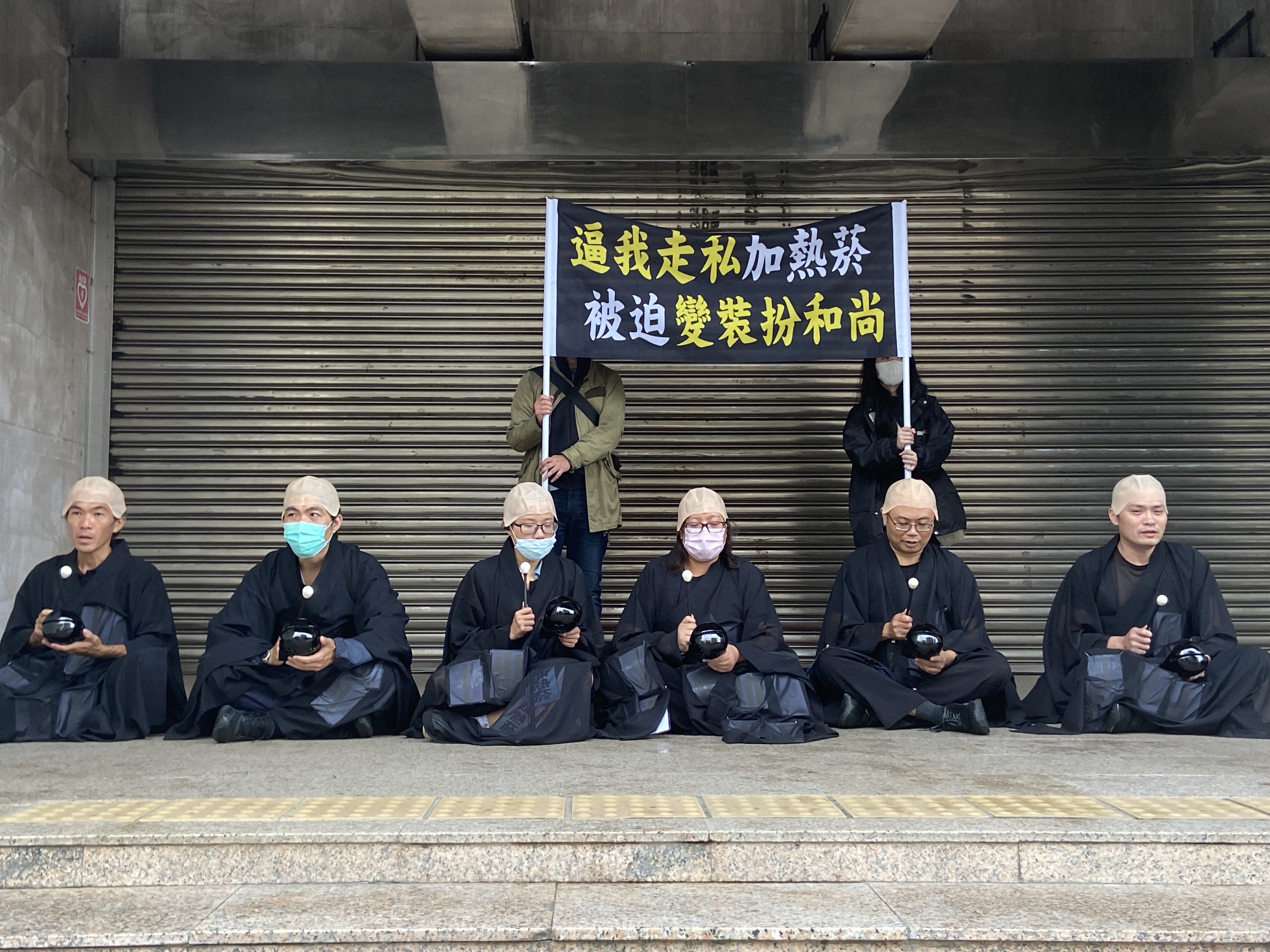 彭華幹號召民團成員扮和尚,海青袈裟內貼滿加熱菸字樣,諷走私入境,水貨商賺進不法暴利。(Clear air大聯盟提供)