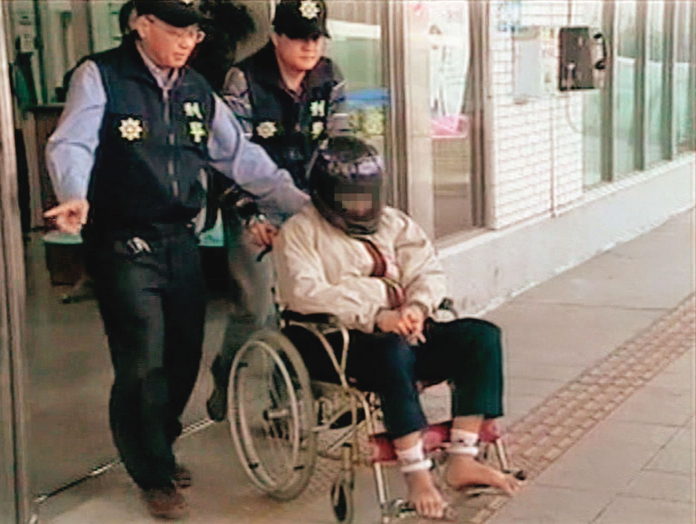 黃姓凶手（坐者）被警方借提時，假裝癲癇、行動不便，最後遭戳破謊言。（東森新聞提供）