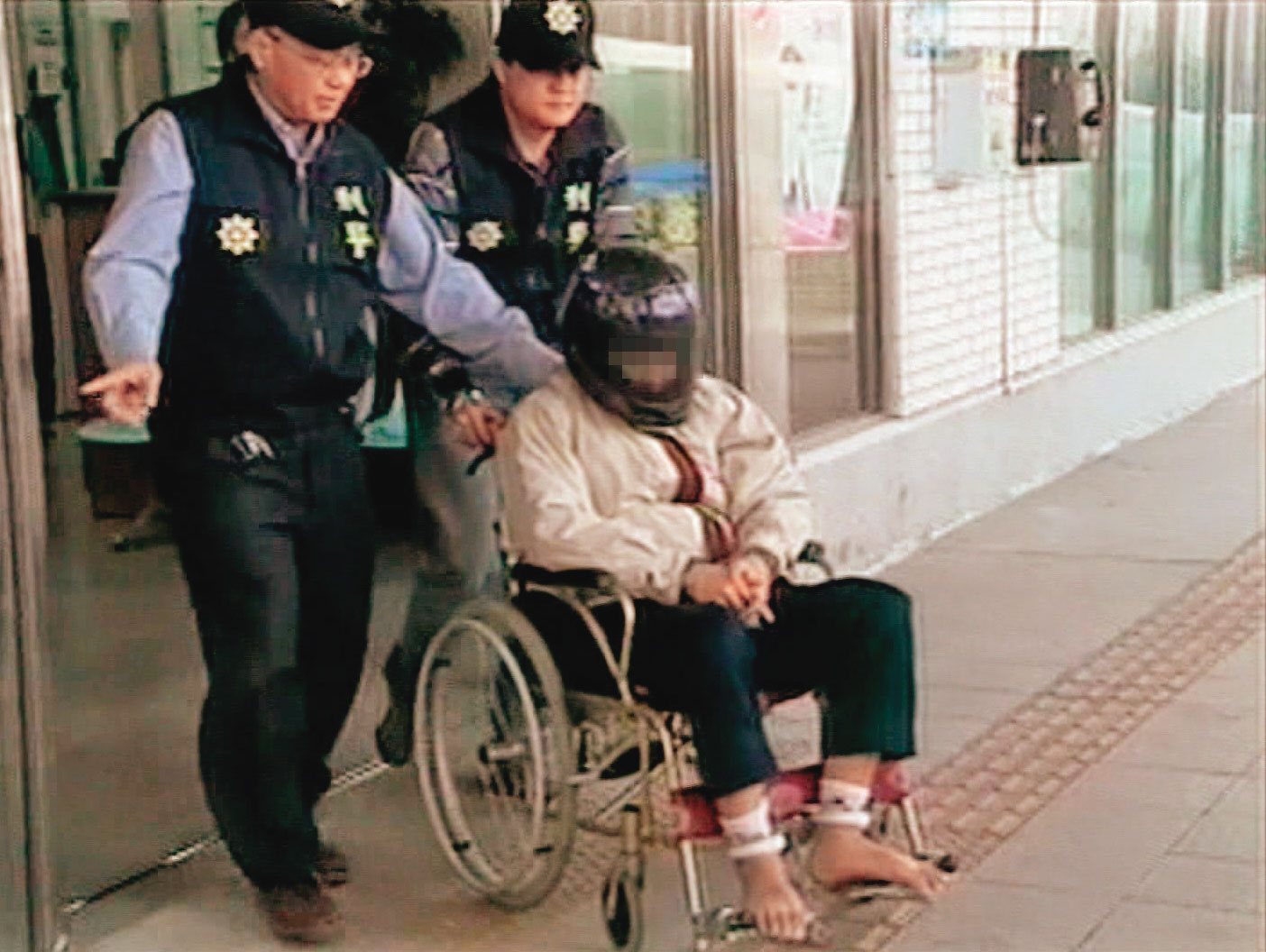 黃姓凶手（坐者）被警方借提時，假裝癲癇、行動不便，最後遭戳破謊言。（東森新聞提供）