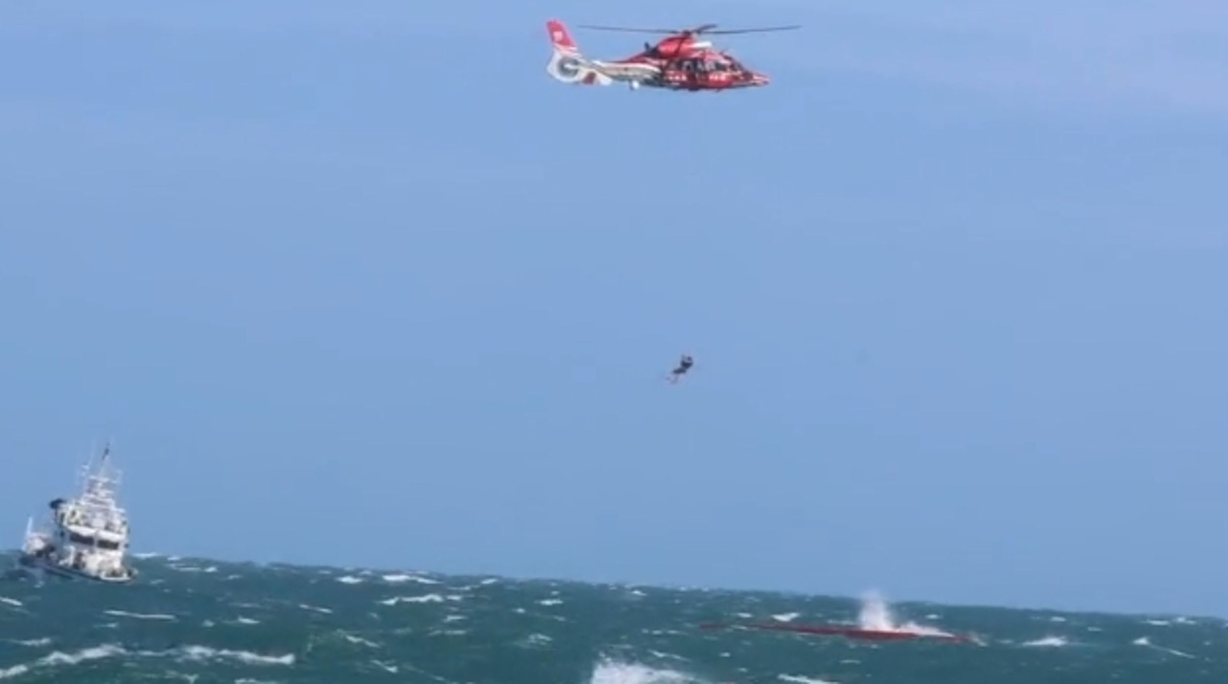 「漁山36號」捕蟹船於台北港外海翻覆,海巡與空勤人員冒浪救援,仍不幸奪走3命。(翻攝畫面)