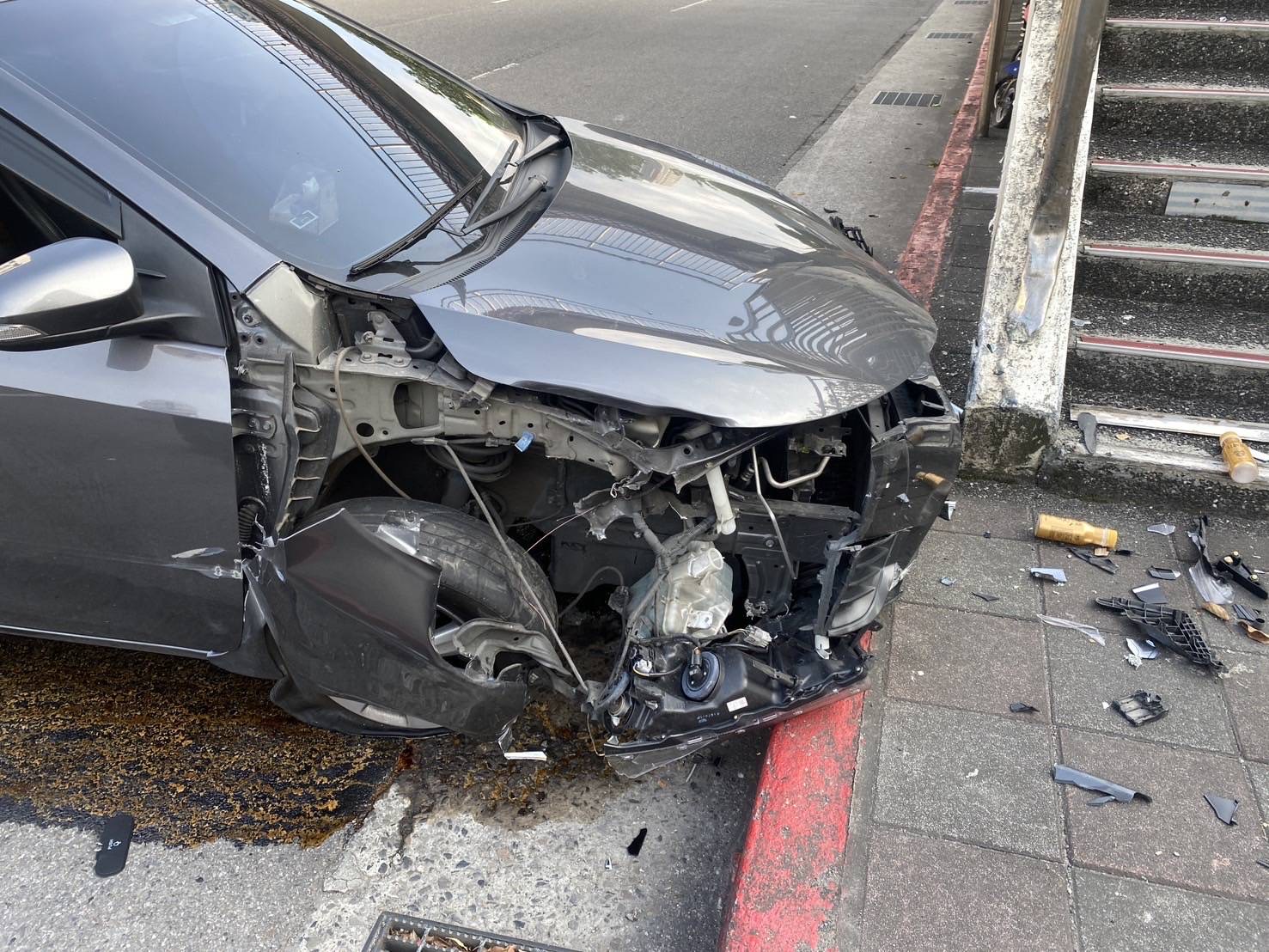 肇事轎車車頭半毀,天橋橋墩也被撞到水泥塊剝落。(翻攝畫面)